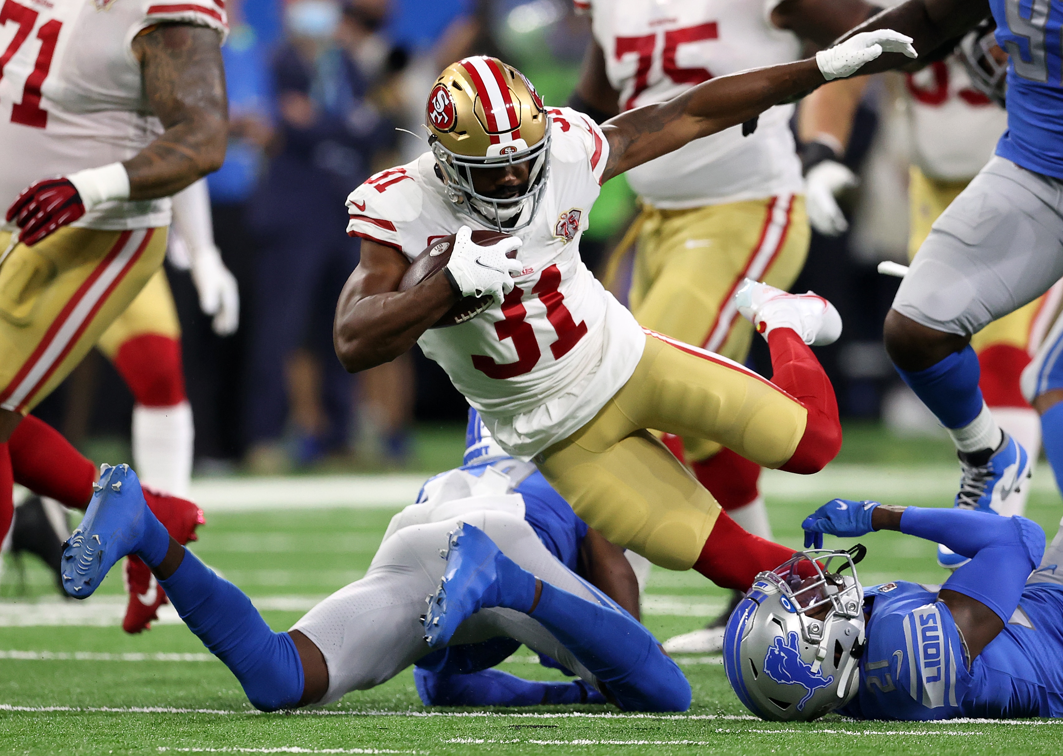 DETROIT, MICHIGAN - SEPTEMBER 12: Raheem Mostert #31 of the San Francisco 49ers is tackled during the first half against the Detroit Lions at Ford Field on September 12, 2021 in Detroit, Michigan. (Photo by Gregory Shamus/Getty Images)