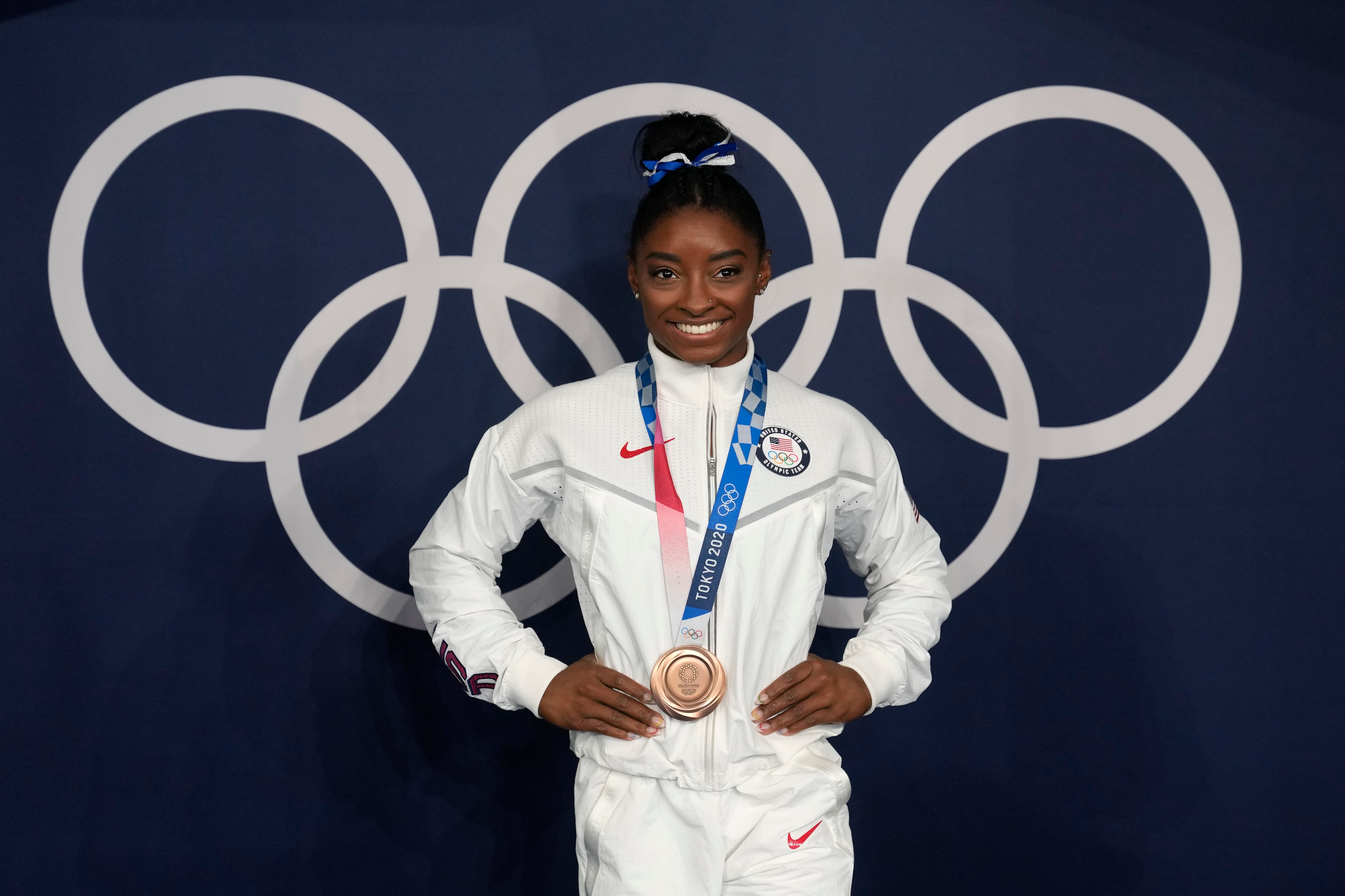 Simone Biles, of the United States, poses wearing her bronze medal from balance beam competition during artistic gymnastics at the 2020 Summer Olympics, Tuesday, Aug. 3, 2021, in Tokyo, Japan. (AP Photo/Natacha Pisarenko)