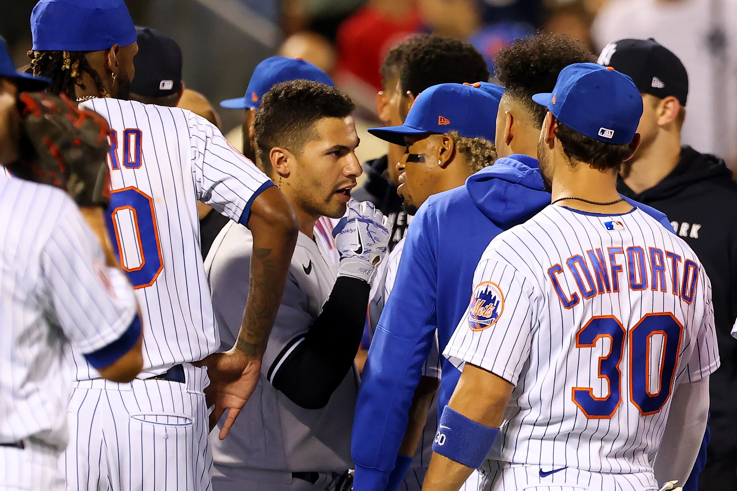 NEW YORK, NY - SEPTEMBER 12: Gleyber Torres #25 of the New York Yankees and Francisco Lindor #12 of the New York Mets exchange word as both teams' benches clear after Giancarlo Stanton #27 of the Yankees hits a two-run home run in the seventh inning of a game at Citi Field on September 12, 2021 in New York City. (Photo by Rich Schultz/Getty Images)