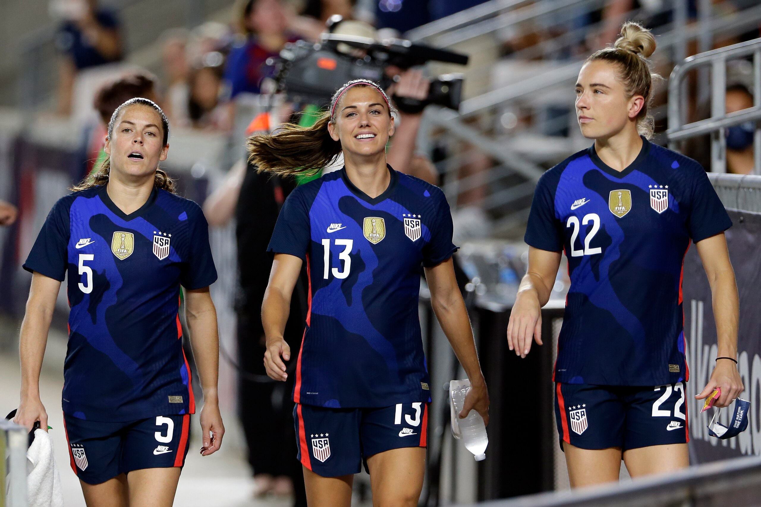 FILE - In this June 13, 2021, file photo, United States defender Kelley O'Hara (5), forward Alex Morgan (13) and midfielder Kristie Mewis (22) walk onto the field before their soccer game against Jamaica in Houston. Morgan says the U.S. women's national team needs to make sure players aren't losing any compensation they currently receive under U.S. Soccer's identical contract proposals for both the men's and women's teams. But the team is hopeful for a new collective bargaining agreement that will address players' concerns about equitable pay, she said. (AP Photo/Michael Wyke, File)