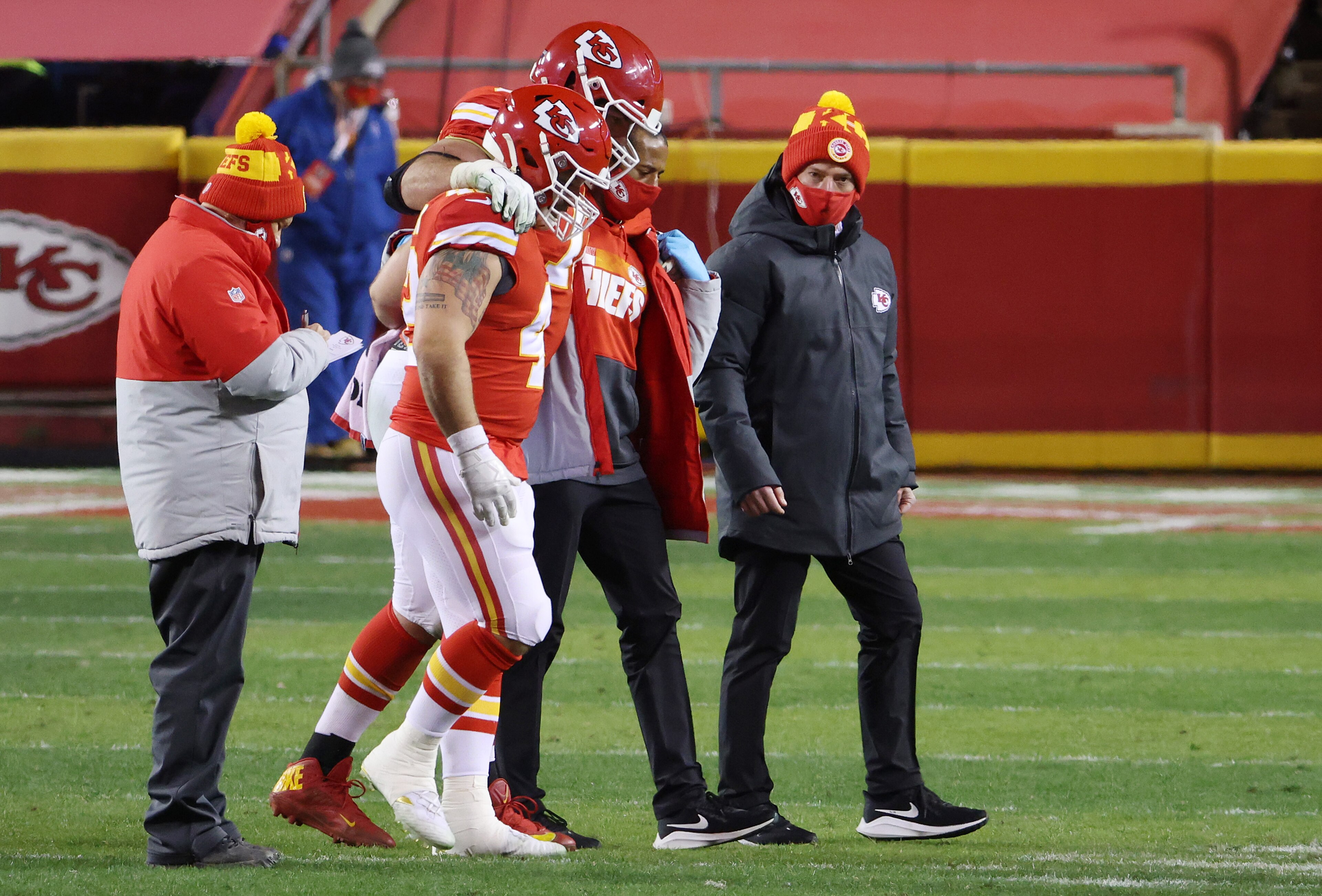 KANSAS CITY, MISSOURI - JANUARY 24: Eric Fisher #72 of the Kansas City Chiefs is helped off the field in the fourth quarter against the Buffalo Bills during the AFC Championship game at Arrowhead Stadium on January 24, 2021 in Kansas City, Missouri. (Photo by Jamie Squire/Getty Images)