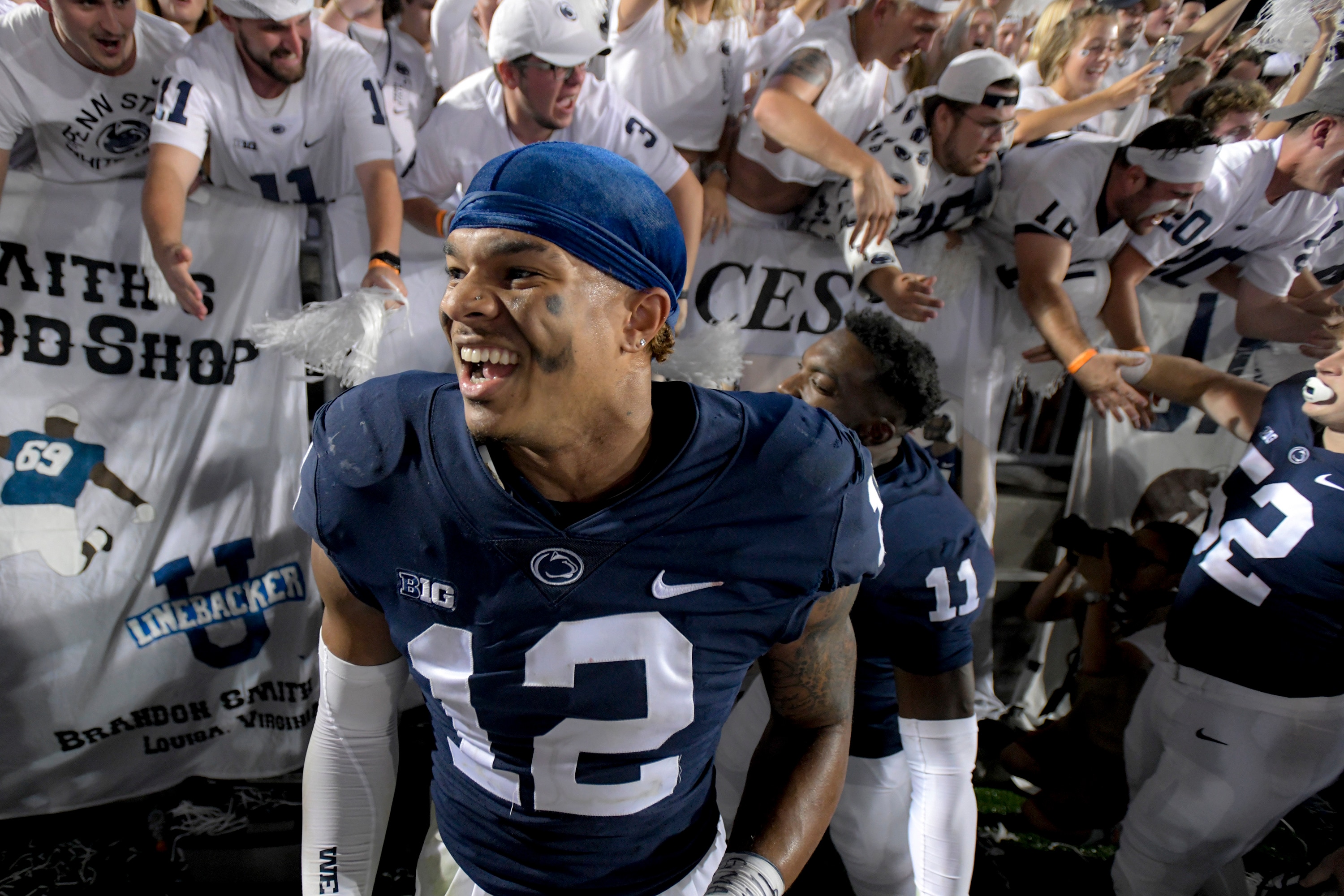 Penn State linebacker Brandon Smith (12) celebrates with fans following the 28-20 victory over Auburn after an NCAA college football game in State College, Pa., on Saturday, Sept. 18, 2021. (AP Photo/Barry Reeger)