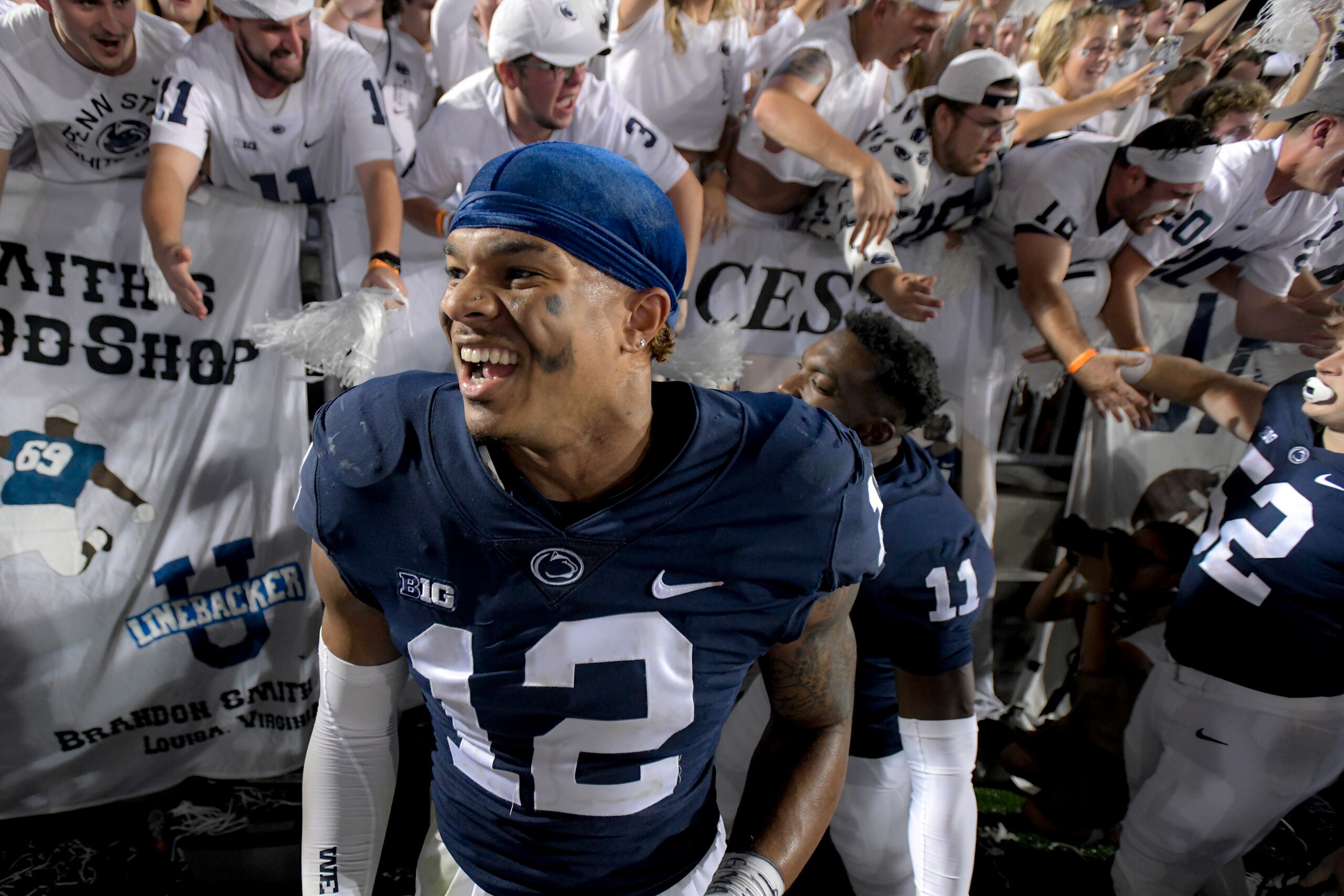 Penn State linebacker Brandon Smith (12) celebrates with fans following the 28-20 victory over Auburn after an NCAA college football game in State College, Pa., on Saturday, Sept. 18, 2021. (AP Photo/Barry Reeger)