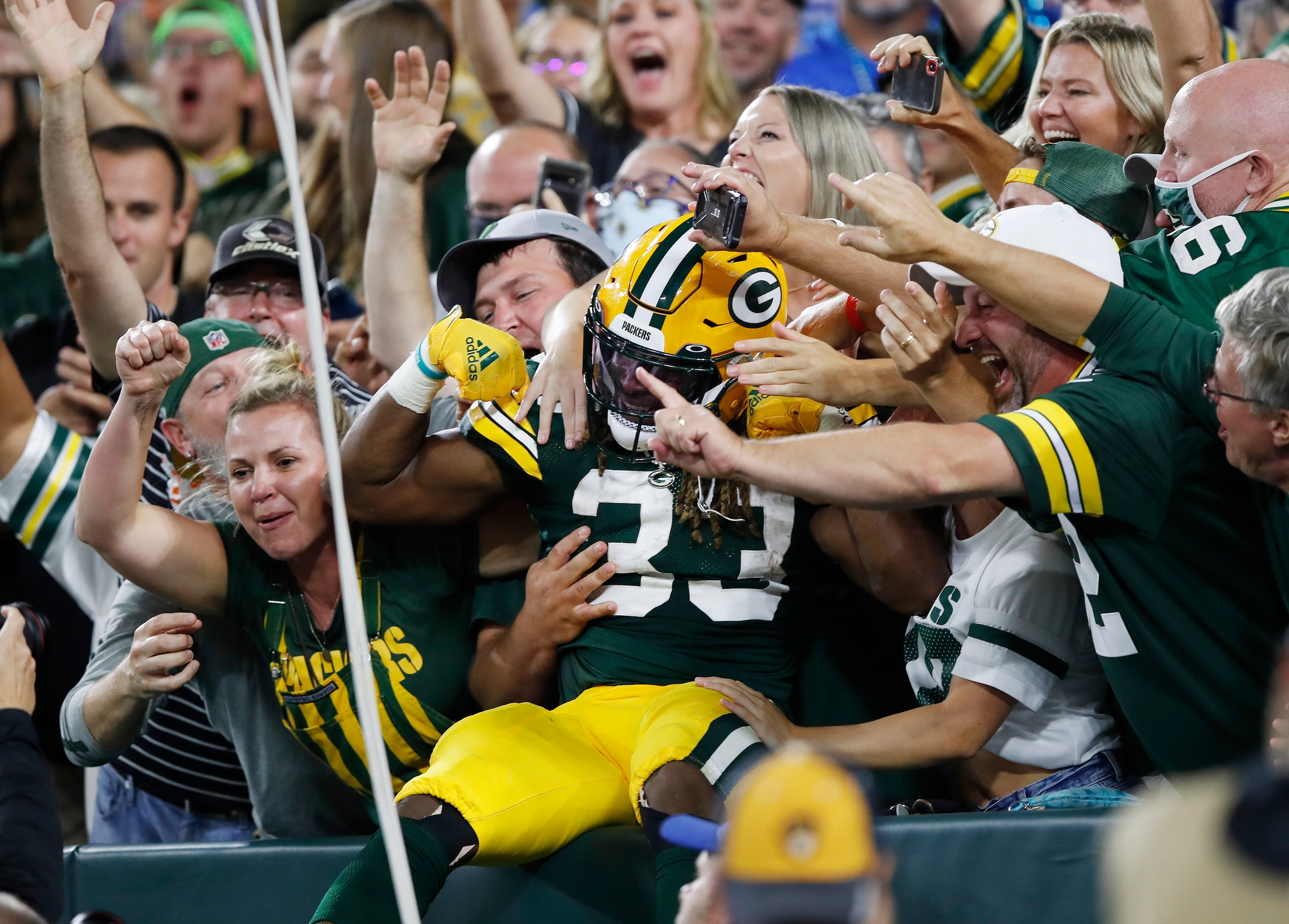 GREEN BAY, WISCONSIN - SEPTEMBER 20: Aaron Jones #33 of the Green Bay Packers does the Lambeau Leap to celebrate a touchdown with fans against the Detroit Lions during the first half at Lambeau Field on September 20, 2021 in Green Bay, Wisconsin. (Photo by Wesley Hitt/Getty Images)