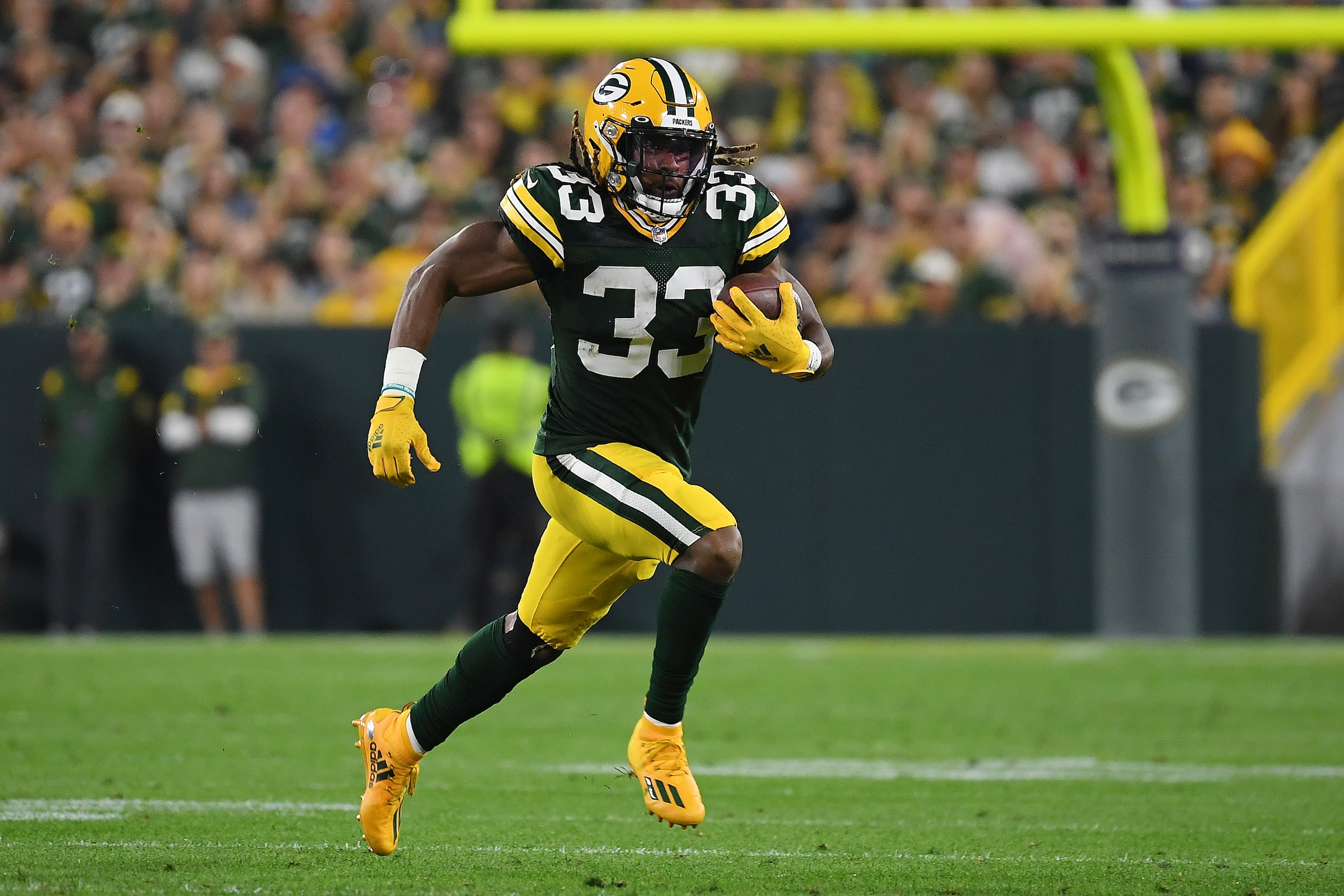 GREEN BAY, WISCONSIN - SEPTEMBER 20: Aaron Jones #33 of the Green Bay Packers runs against the Detroit Lions during the first half at Lambeau Field on September 20, 2021 in Green Bay, Wisconsin. (Photo by Quinn Harris/Getty Images)