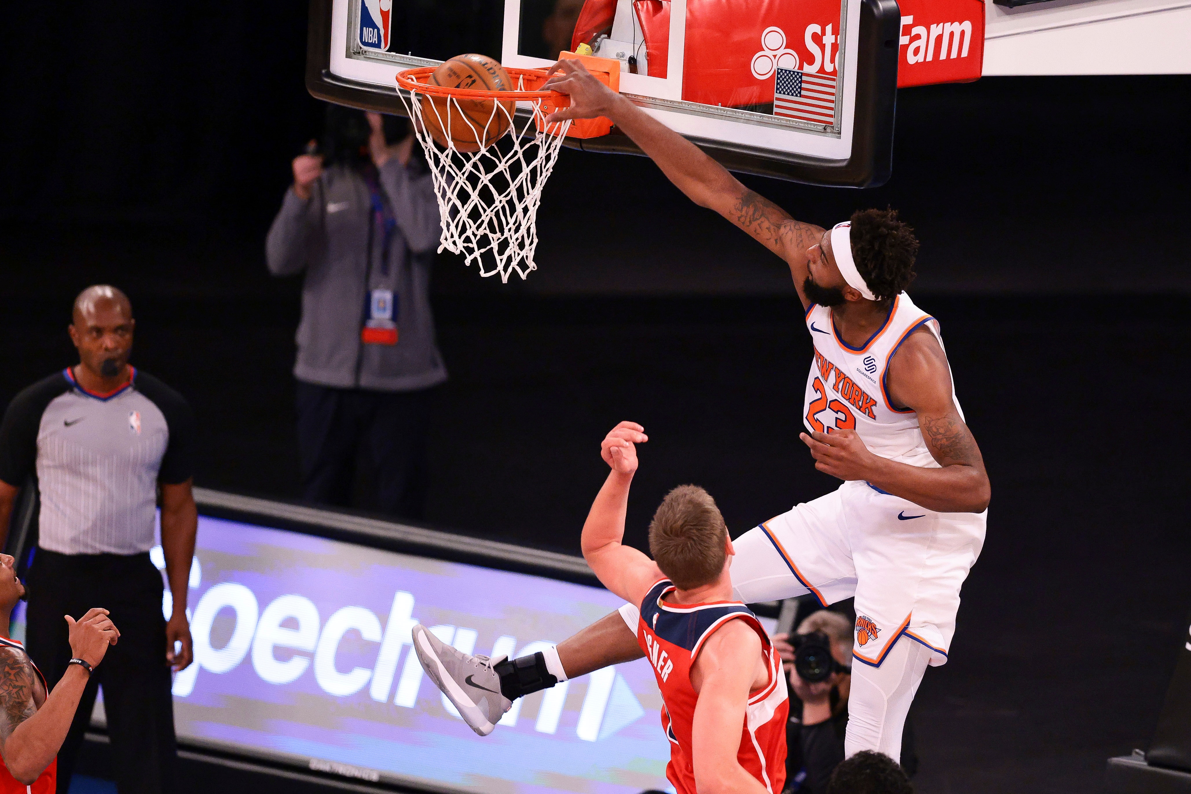New York Knicks center Mitchell Robinson (23) dunks the ball over Washington Wizards center Moritz Wagner (21) during the first half of an NBA basketball game Tuesday, March 23, 2021, in New York. (Vincent Carchietta/Pool Photo via AP)
