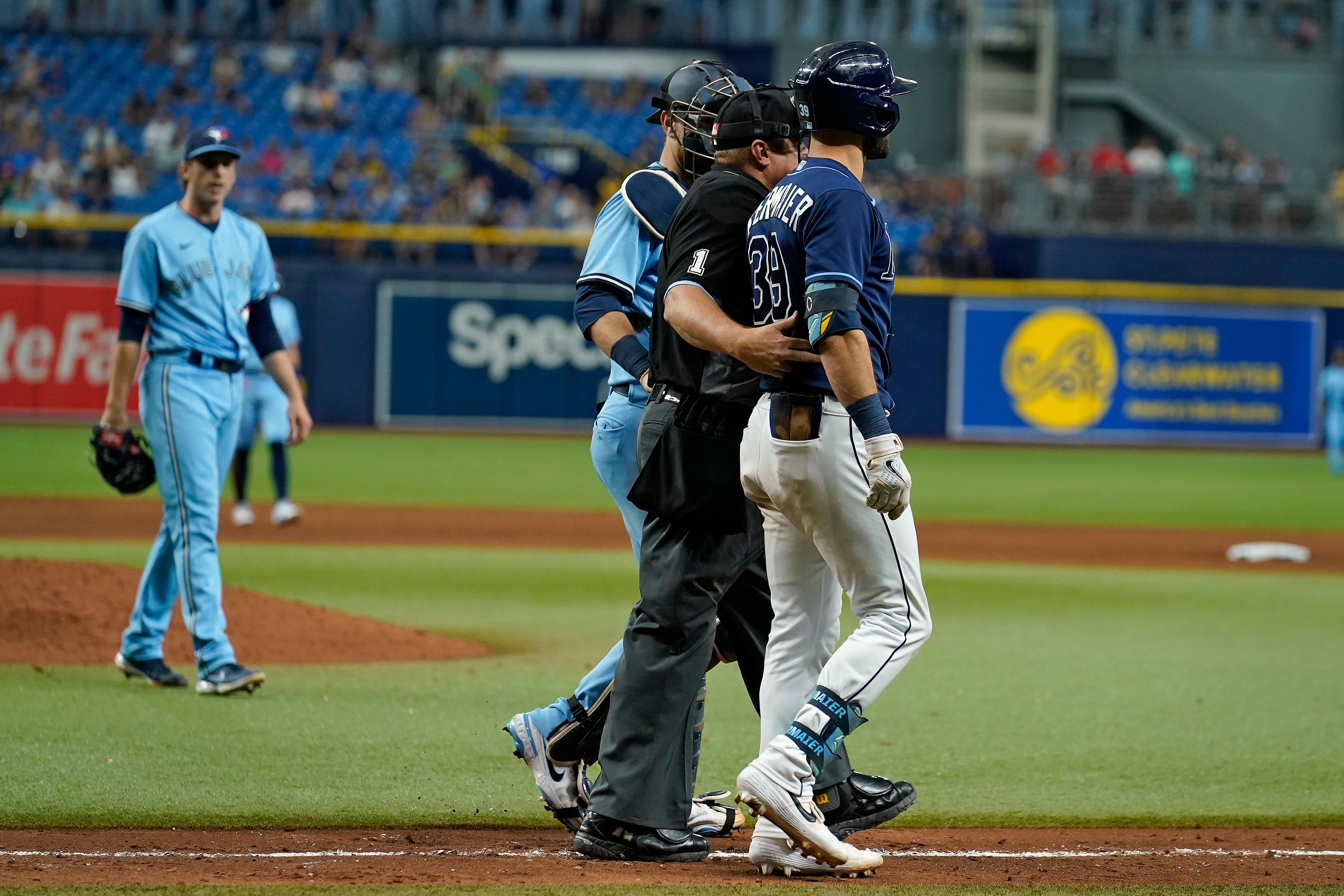Tampa Bay Rays' Kevin Kiermaier, right, is held back by home plate umpire Bruce Dreckman and Toronto Blue Jays catcher Danny Jansen after Kiermaier was hit with a pitch by starting pitcher Ryan Borucki, right, during the eighth inning of a baseball game Wednesday, Sept. 22, 2021, in St. Petersburg, Fla. (AP Photo/Chris O'Meara)