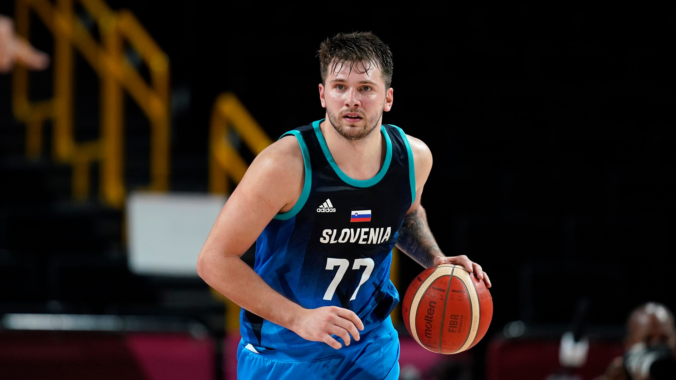 Slovenia's Luka Doncic (77) drives up court during a men's basketball semifinal round game against France at the 2020 Summer Olympics, Thursday, Aug. 5, 2021, in Saitama, Japan. (AP Photo/Charlie Neibergall)