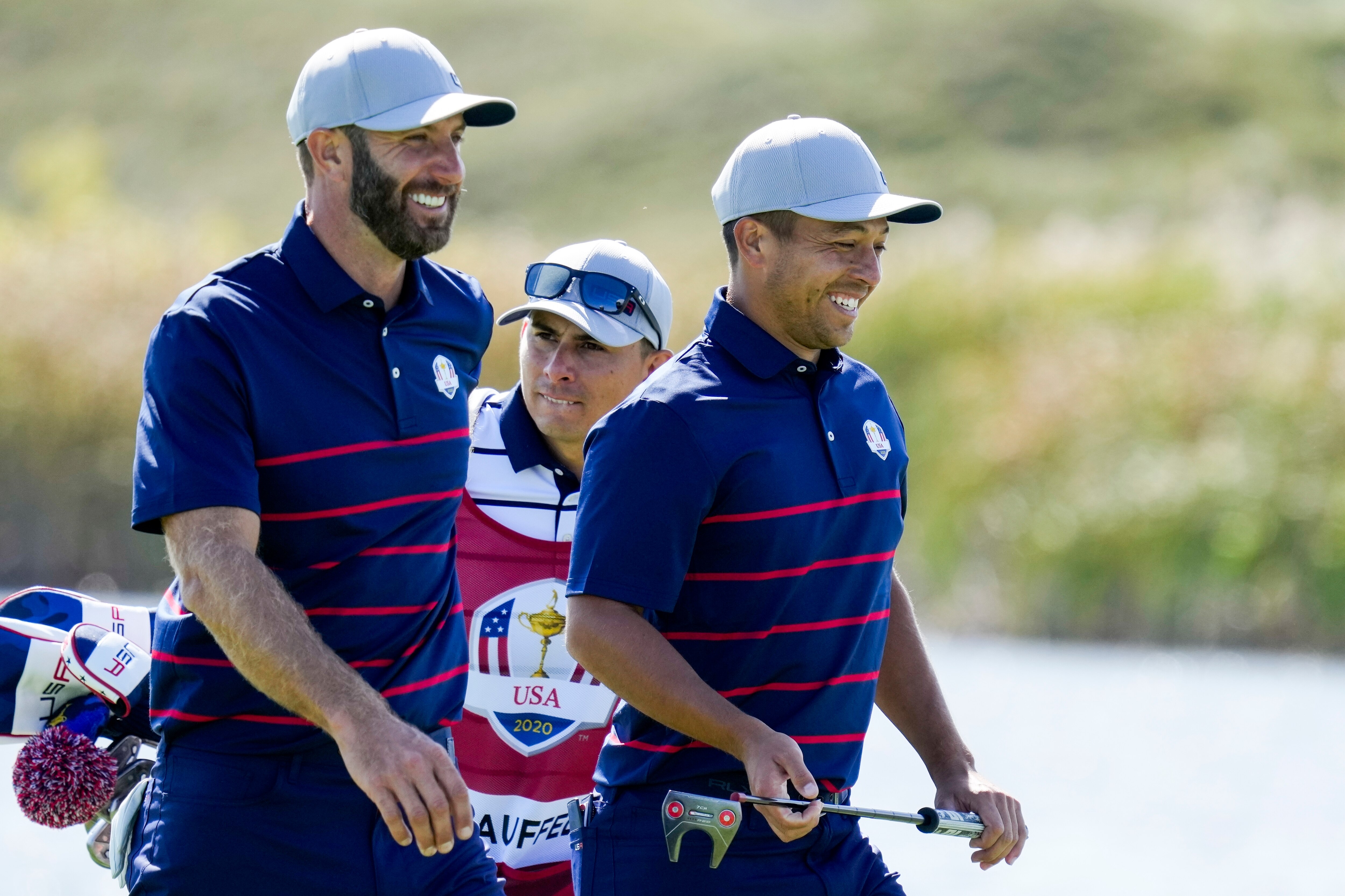 Team USA's Dustin Johnson and Team USA's Xander Schauffele smile as they walk up the fifth hole during a four-ball match the Ryder Cup at the Whistling Straits Golf Course Friday, Sept. 24, 2021, in Sheboygan, Wis. (AP Photo/Ashley Landis)