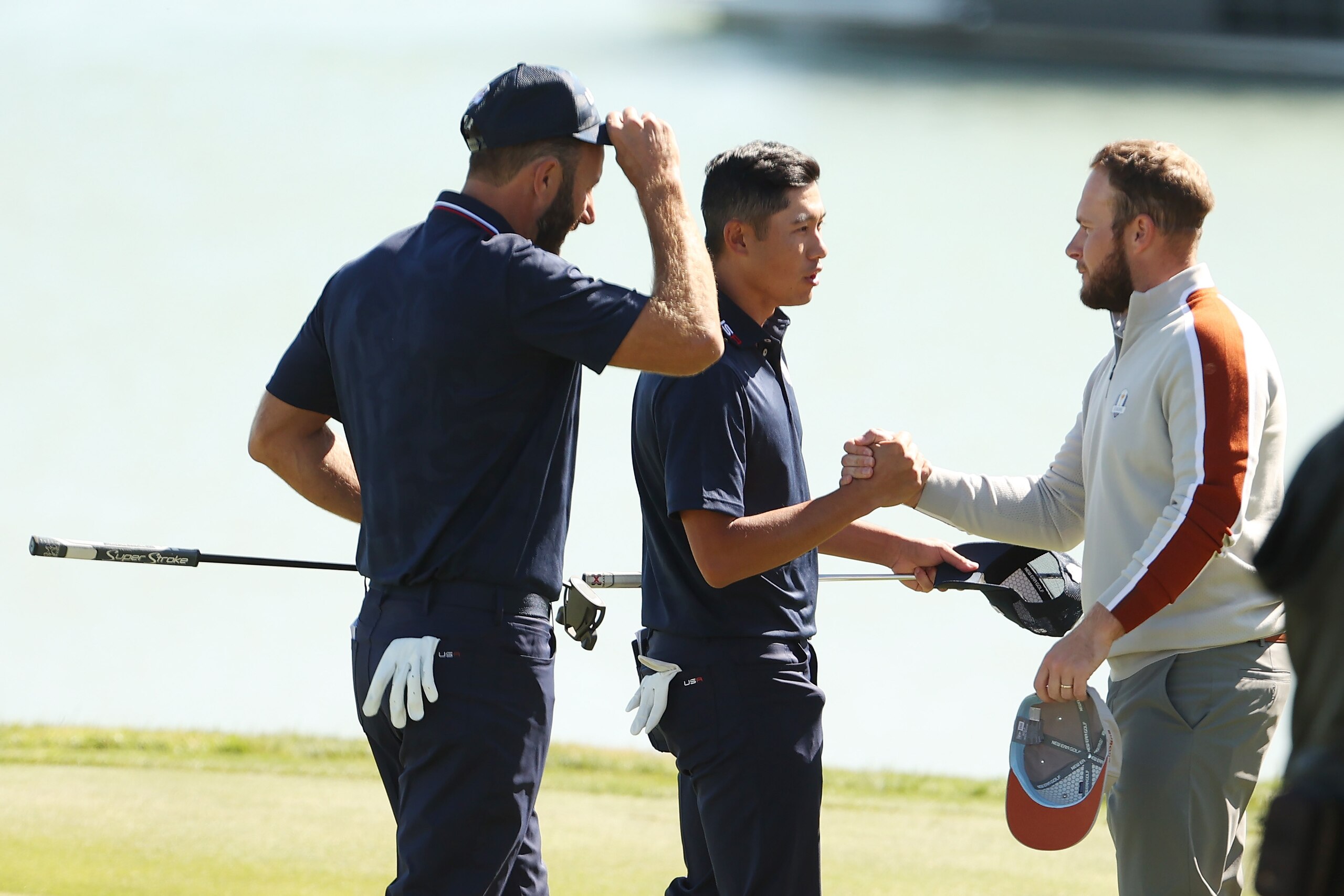 KOHLER, WISCONSIN - SEPTEMBER 25: (L-R) Dustin Johnson of team United States, Collin Morikawa of team United States, and Tyrrell Hatton of England and team Europe shake hands on the 17th green during Saturday Morning Foursome Matches of the 43rd Ryder Cup at Whistling Straits on September 25, 2021 in Kohler, Wisconsin. (Photo by Maddie Meyer/PGA of America/PGA of America via Getty Images )