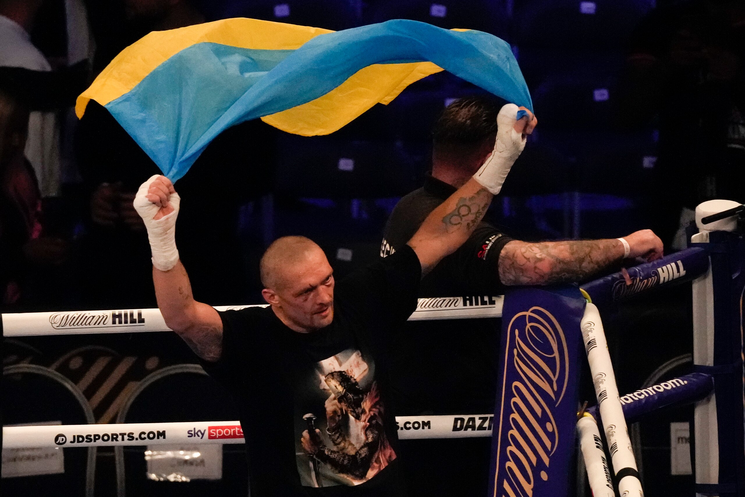 Oleksandr Usyk of Ukraine holds up the Ukrainian flag after his unanimous decision victory over Anthony Joshua of Britain in their WBA (Super), WBO and IBF boxing title bout at the Tottenham Hotspur Stadium in London, Saturday, Sept. 25, 2021. (AP Photo/Frank Augstein)