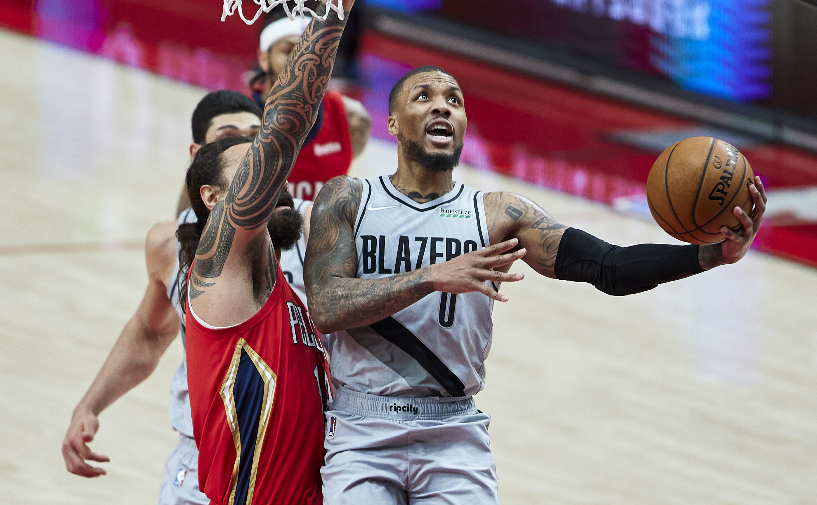 El base de los Trail Blazers de Portland Damian Lillard dispara sobre la defensiva del pívot de los Pelicans de Nueva Orleans Steven Adams en la segunda mitad del juego del martes 16 de marzo de 2021, en Portland, Oregon. (AP Foto/Craig Mitchelldyer)