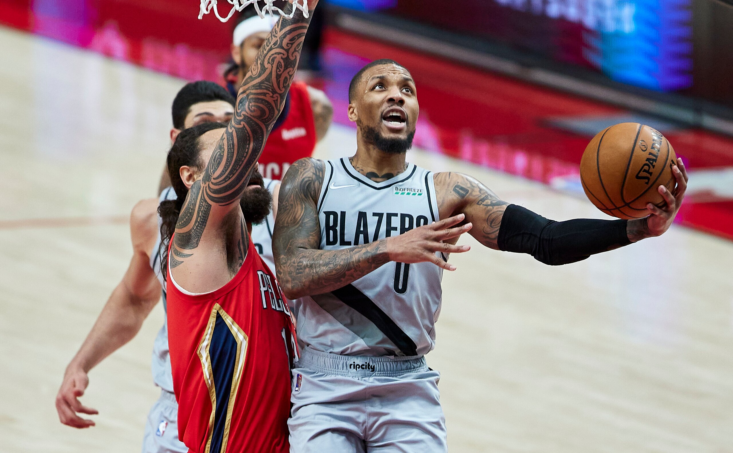 El base de los Trail Blazers de Portland Damian Lillard dispara sobre la defensiva del pívot de los Pelicans de Nueva Orleans Steven Adams en la segunda mitad del juego del martes 16 de marzo de 2021, en Portland, Oregon. (AP Foto/Craig Mitchelldyer)
