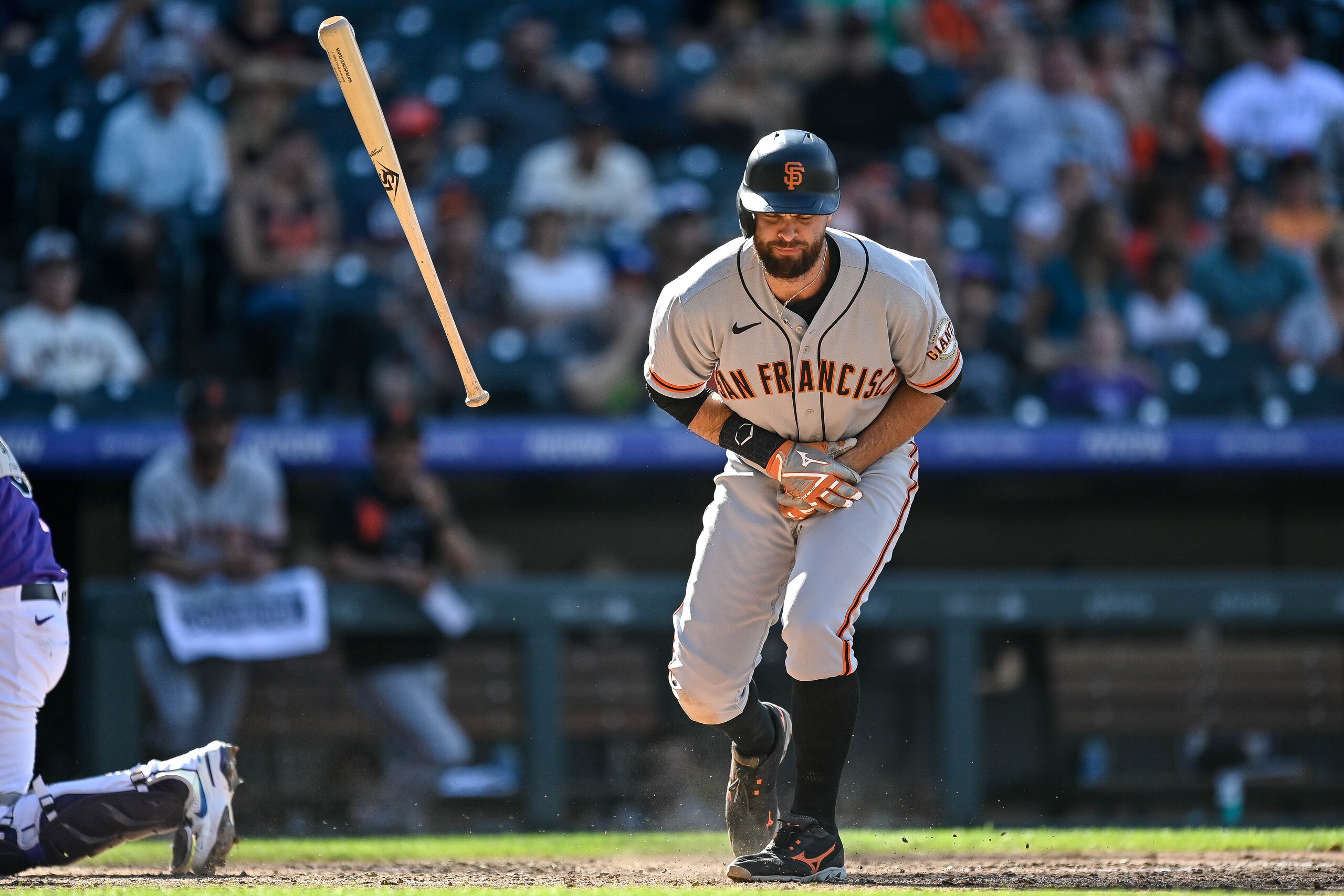 DENVER, CO - SEPTEMBER 26: Brandon Belt #9 of the San Francisco Giants reacts after being hit by a pitch in the seventh inning during a game against the Colorado Rockies at Coors Field on September 26, 2021 in Denver, Colorado. (Photo by Dustin Bradford/Getty Images)