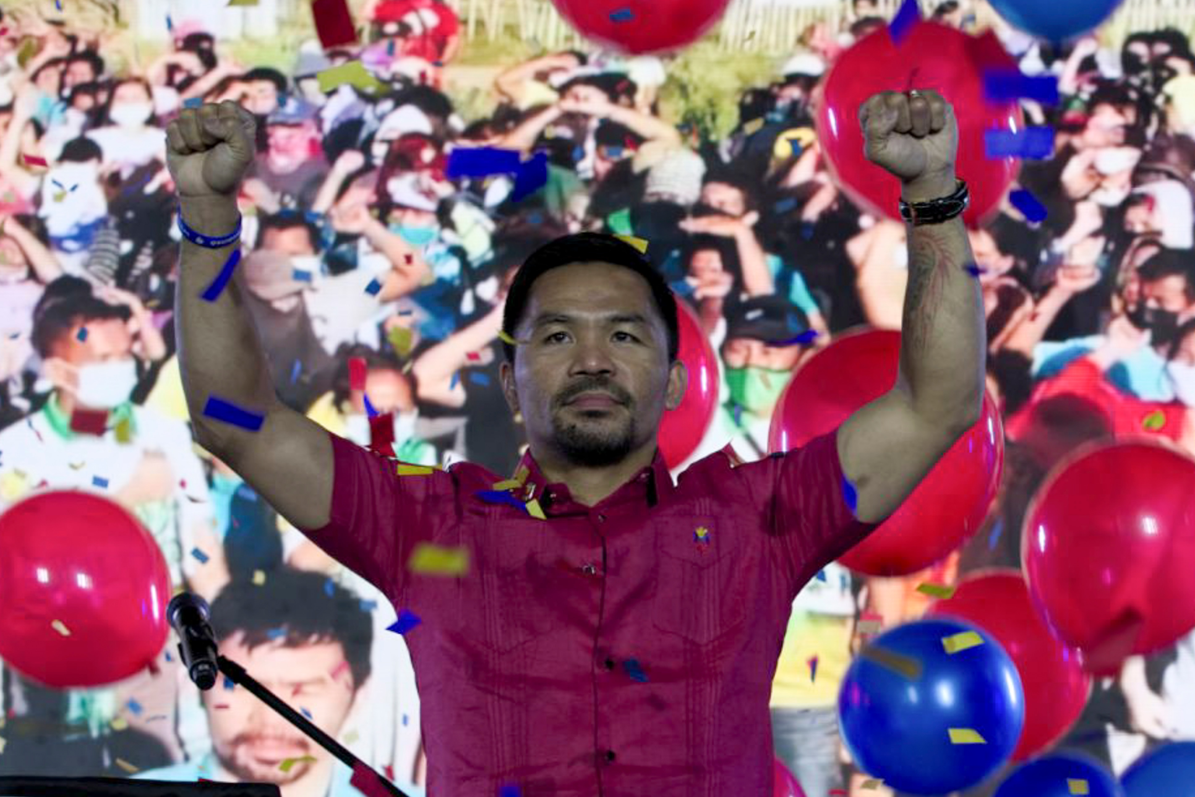 In this photo provided by the Manny Pacquiao MediaComms, Senator Manny Pacquiao raises his hands during a national convention of his PDP-Laban party in Quezon city, Philippines on Sunday Sept. 19, 2021. Philippine boxing icon and senator Manny Pacquiao says he will run for president in the 2022 elections. (Manny Pacquiao MediaComms via AP)