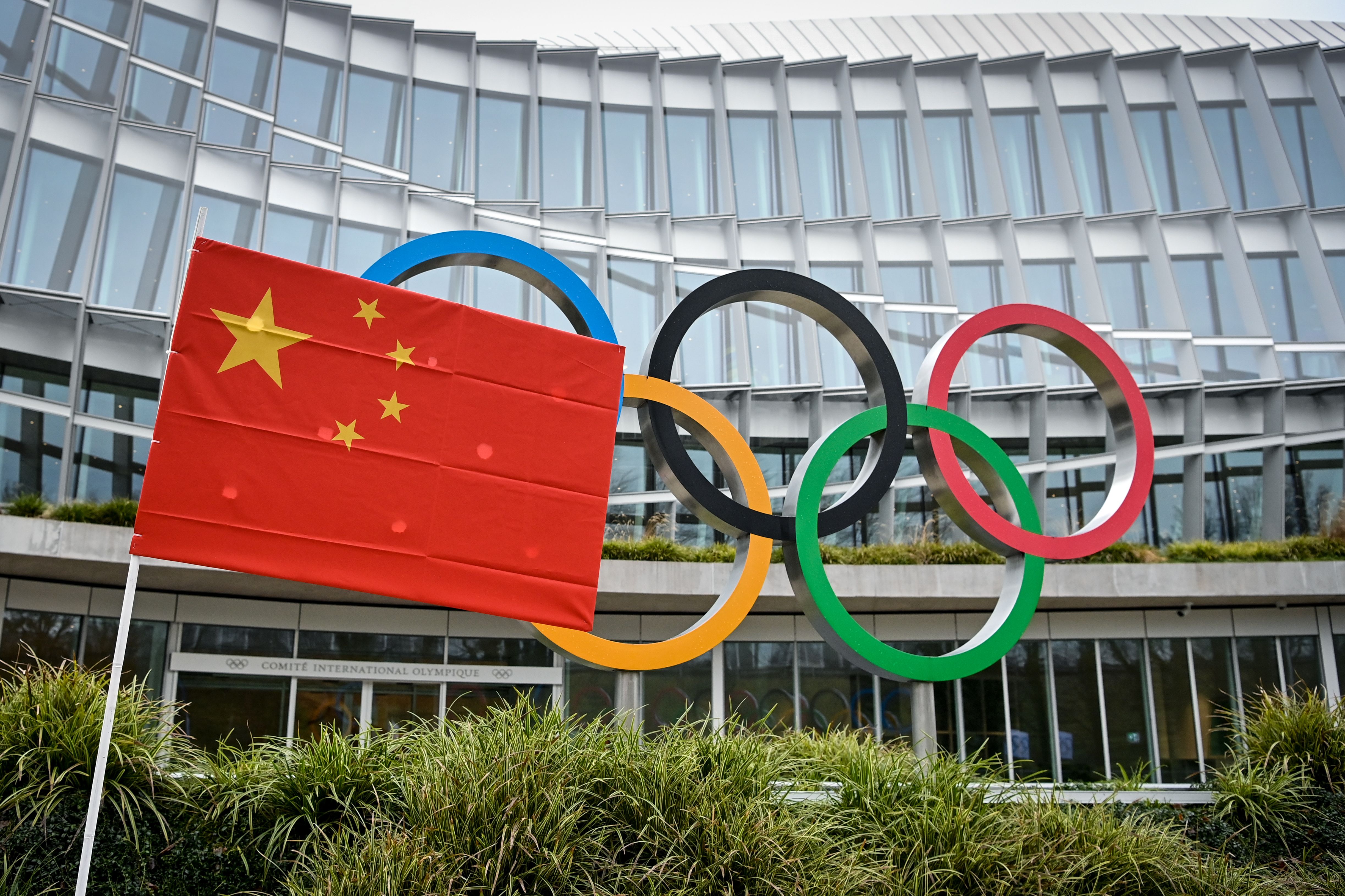 A Chinese flag flutters in front of the IOC headquarters during a protest by activists of the International Tibet Network against the Beijing 2022 Winter Olympics on Februay 3, 2021 in Lausanne. - A coalition of campaign groups issued an open letter calling on world leaders to boycott the Beijing 2022 Winter Olympics over China's rights record. The Games are scheduled to begin on February 4 next year, just six months after the delayed summer Tokyo Olympics, but preparations have been overshadowed by the coronavirus pandemic. (Photo by Fabrice COFFRINI / AFP) (Photo by FABRICE COFFRINI/AFP via Getty Images)