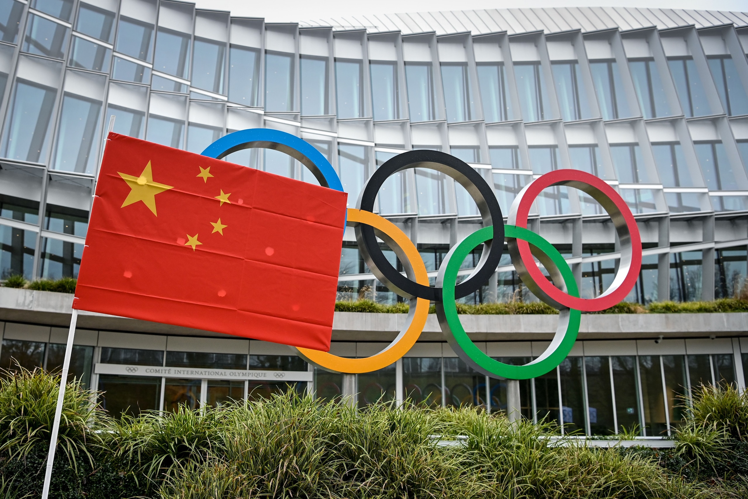 A Chinese flag flutters in front of the IOC headquarters during a protest by activists of the International Tibet Network against the Beijing 2022 Winter Olympics on Februay 3, 2021 in Lausanne. - A coalition of campaign groups issued an open letter calling on world leaders to boycott the Beijing 2022 Winter Olympics over China's rights record. The Games are scheduled to begin on February 4 next year, just six months after the delayed summer Tokyo Olympics, but preparations have been overshadowed by the coronavirus pandemic. (Photo by Fabrice COFFRINI / AFP) (Photo by FABRICE COFFRINI/AFP via Getty Images)