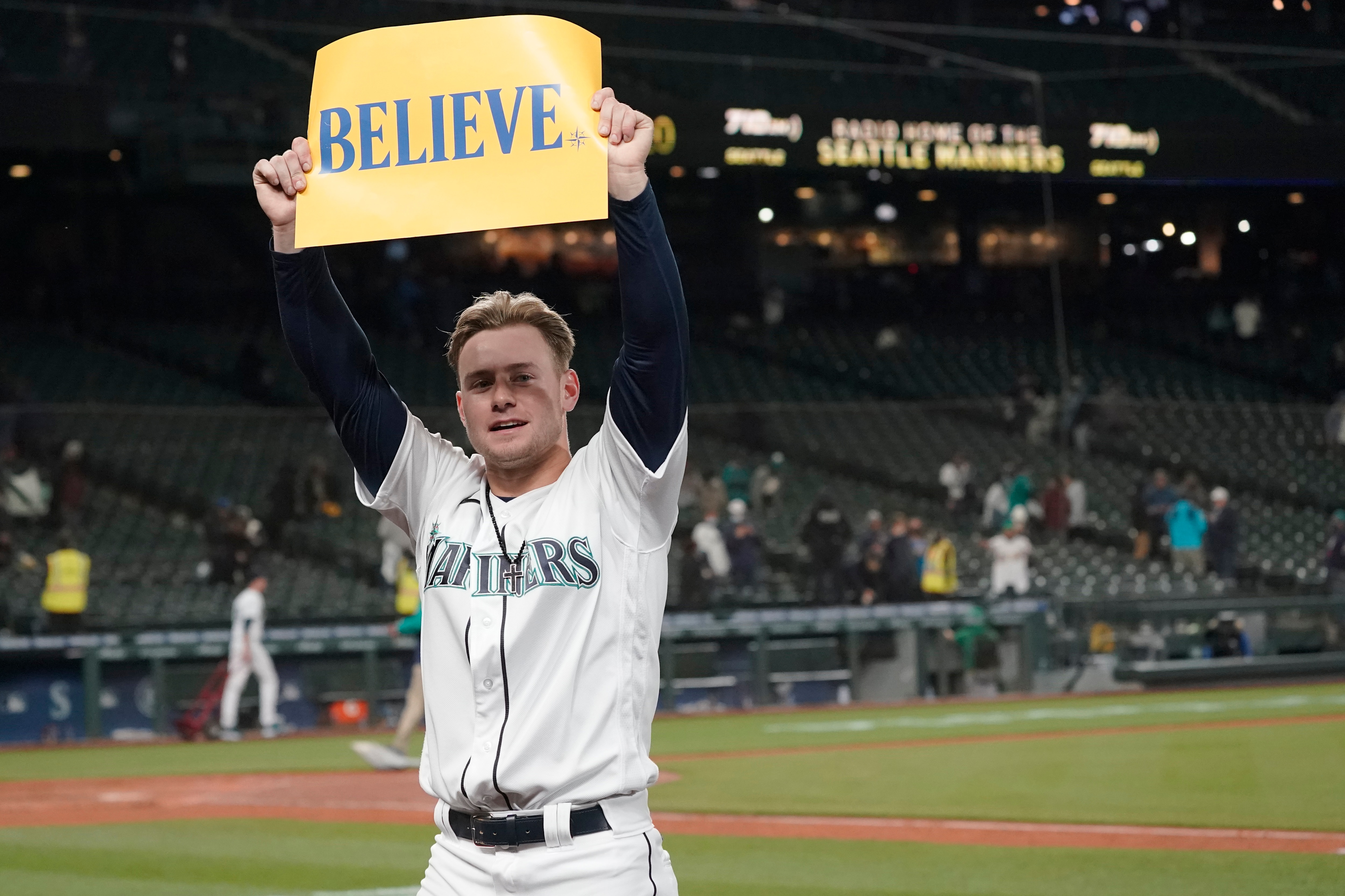Seattle Mariners' Jarred Kelenic holds up a sign that read "Believe" after the Mariners beat the Oakland Athletics 4-2 in a baseball game, Wednesday, Sept. 29, 2021, in Seattle. Fans and the team have adopted the one-word slogan that was recently featured on the TV series "Ted Lasso" as the Mariners battle for a spot in the MLB playoffs. (AP Photo/Ted S. Warren)