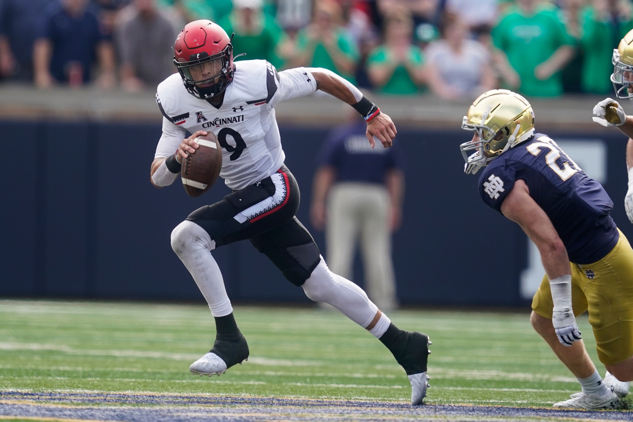 Cincinnati quarterback Desmond Ridder runs from Notre Dame's JD Bertrand (27) during the first half of an NCAA college football game, Saturday, Oct. 2, 2021, in South Bend, Ind. (AP Photo/Darron Cummings)
