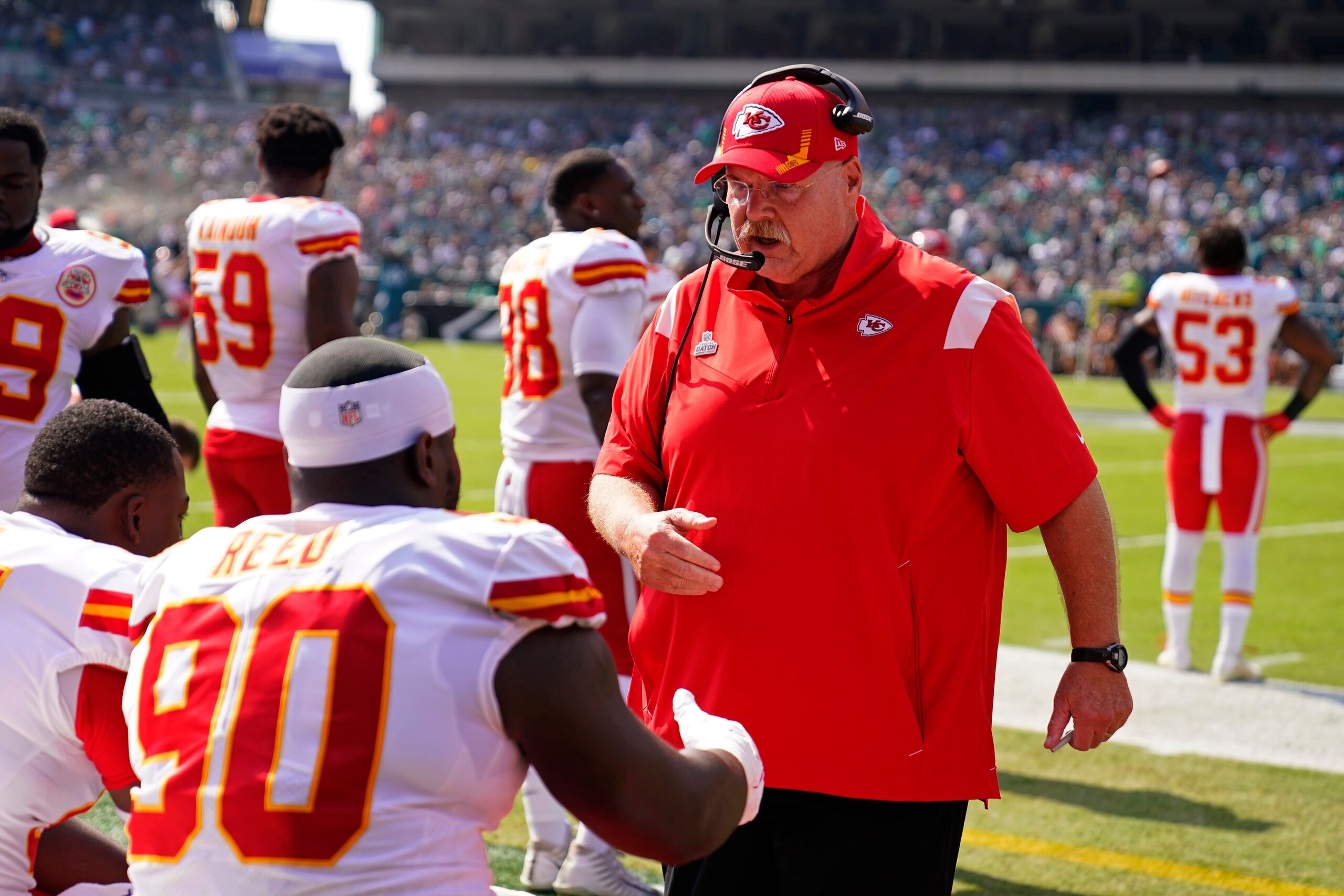Kansas City Chiefs head coach Andy Reid talks to Kansas City Chiefs defensive tackle Jarran Reed (90) before an NFL football game against the Philadelphia Eagles on Sunday, Oct. 3, 2021, in Philadelphia. (AP Photo/Matt Rourke)