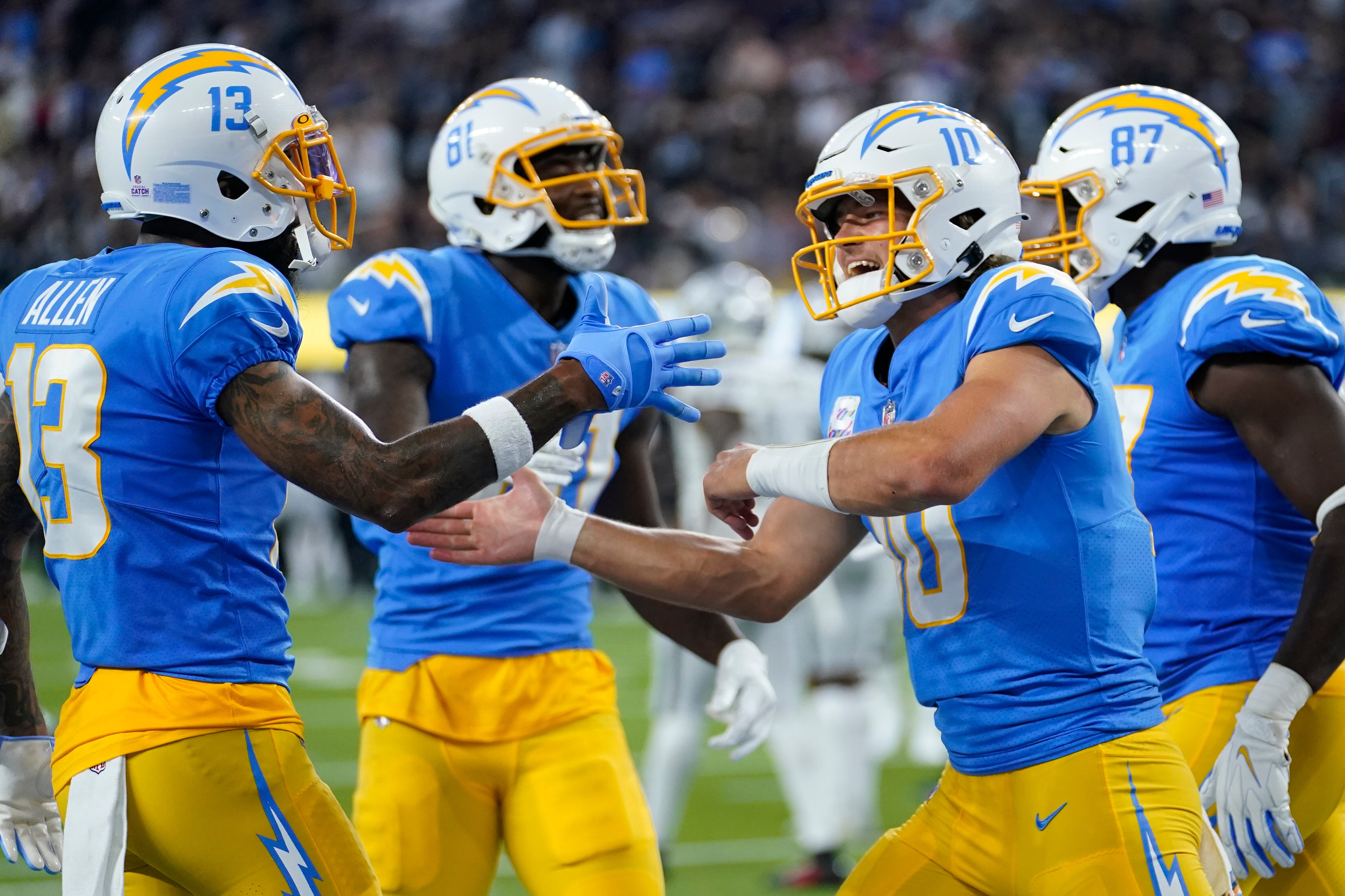 Los Angeles Chargers quarterback Justin Herbert, second from right, reacts after a touchdown during the first half of an NFL football game against the Las Vegas Raiders, Monday, Oct. 4, 2021, in Inglewood, Calif. (AP Photo/Marcio Jose Sanchez)