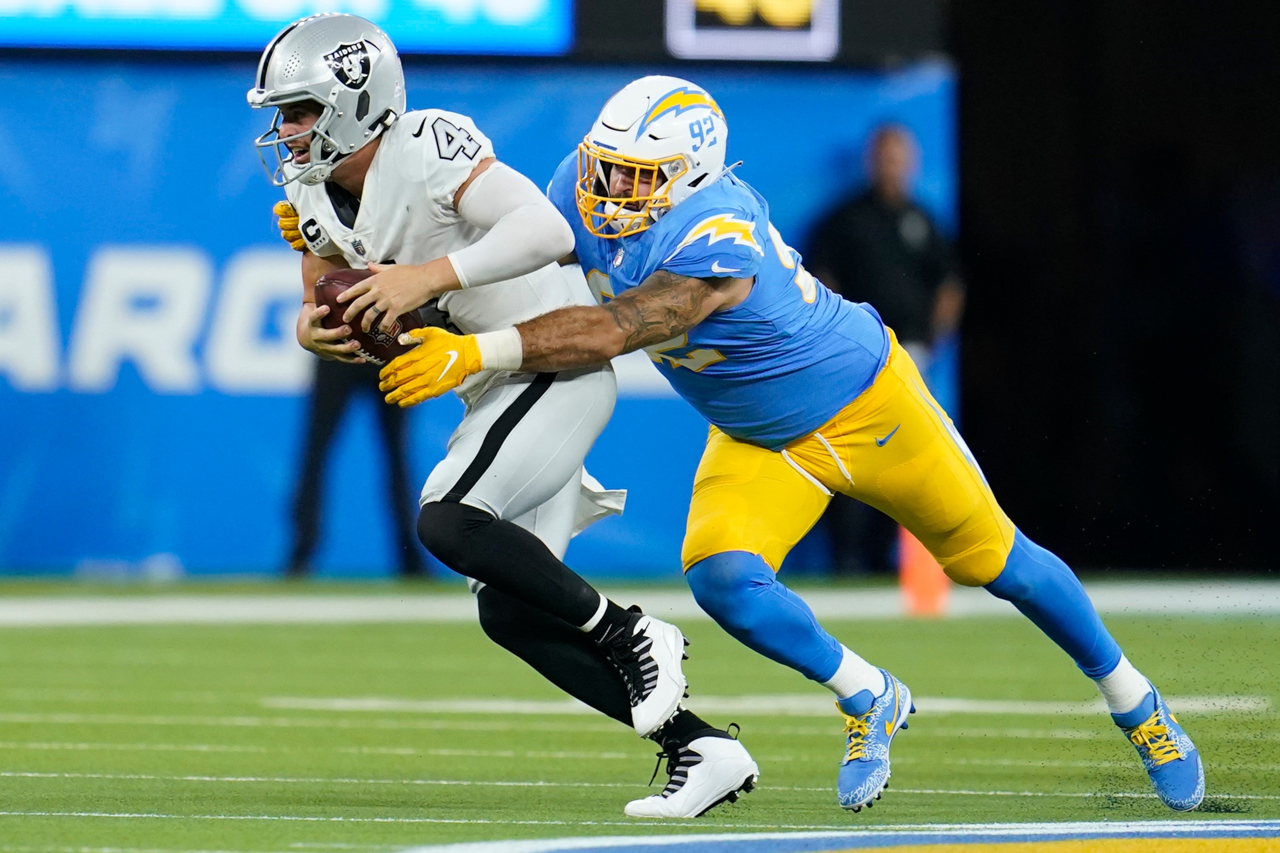Los Angeles Chargers defensive end Joe Gaziano hauls down Las Vegas Raiders quarterback Derek Carr for a sack during the second half of an NFL football game Monday, Oct. 4, 2021, in Inglewood, Calif. (AP Photo/Marcio Jose Sanchez)