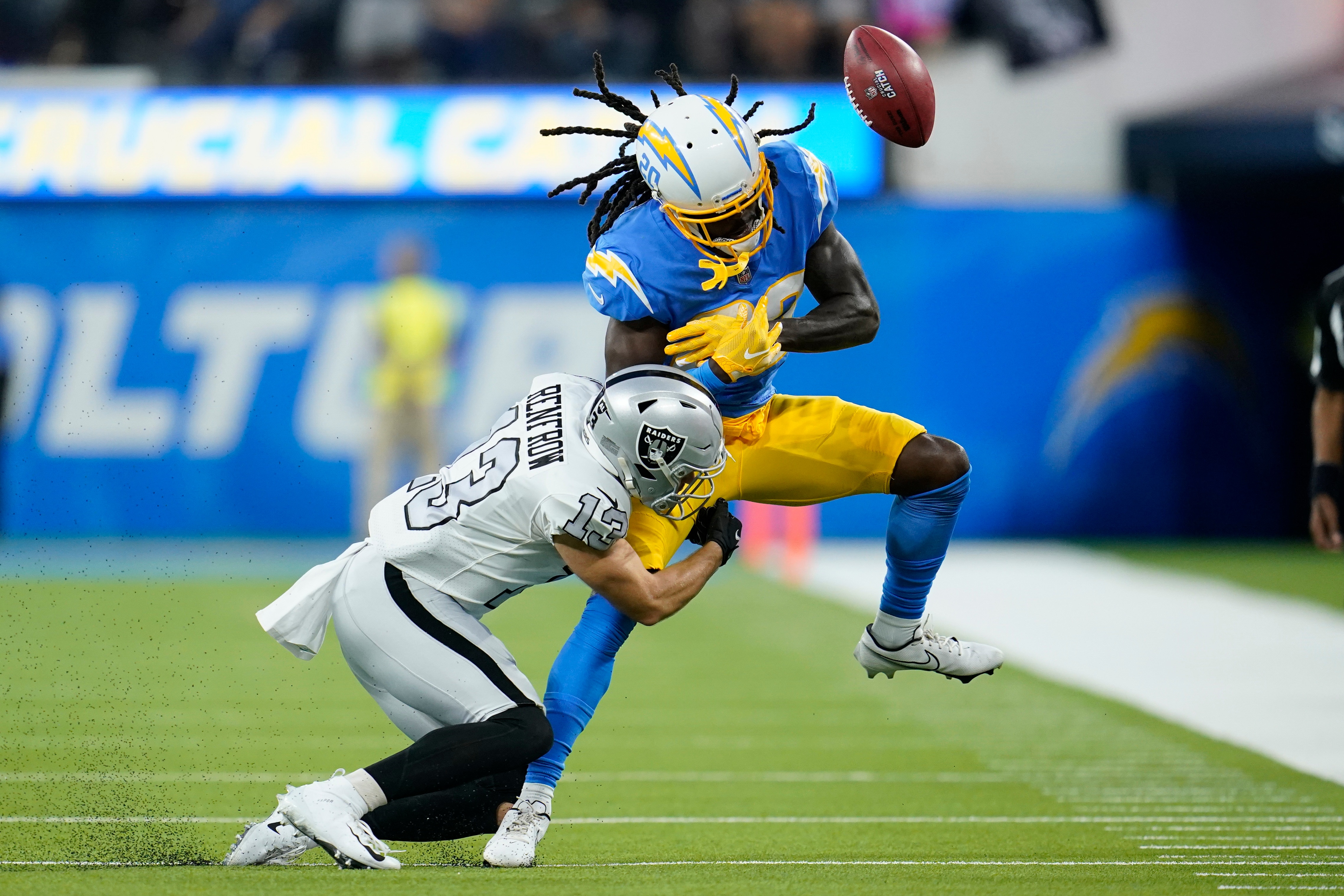 Los Angeles Chargers defensive back Tevaughn Campbell, right, can't make the catch on a fake punt as he is hit by Las Vegas Raiders wide receiver Hunter Renfrow during the first half of an NFL football game Monday, Oct. 4, 2021, in Inglewood, Calif. (AP Photo/Marcio Jose Sanchez)