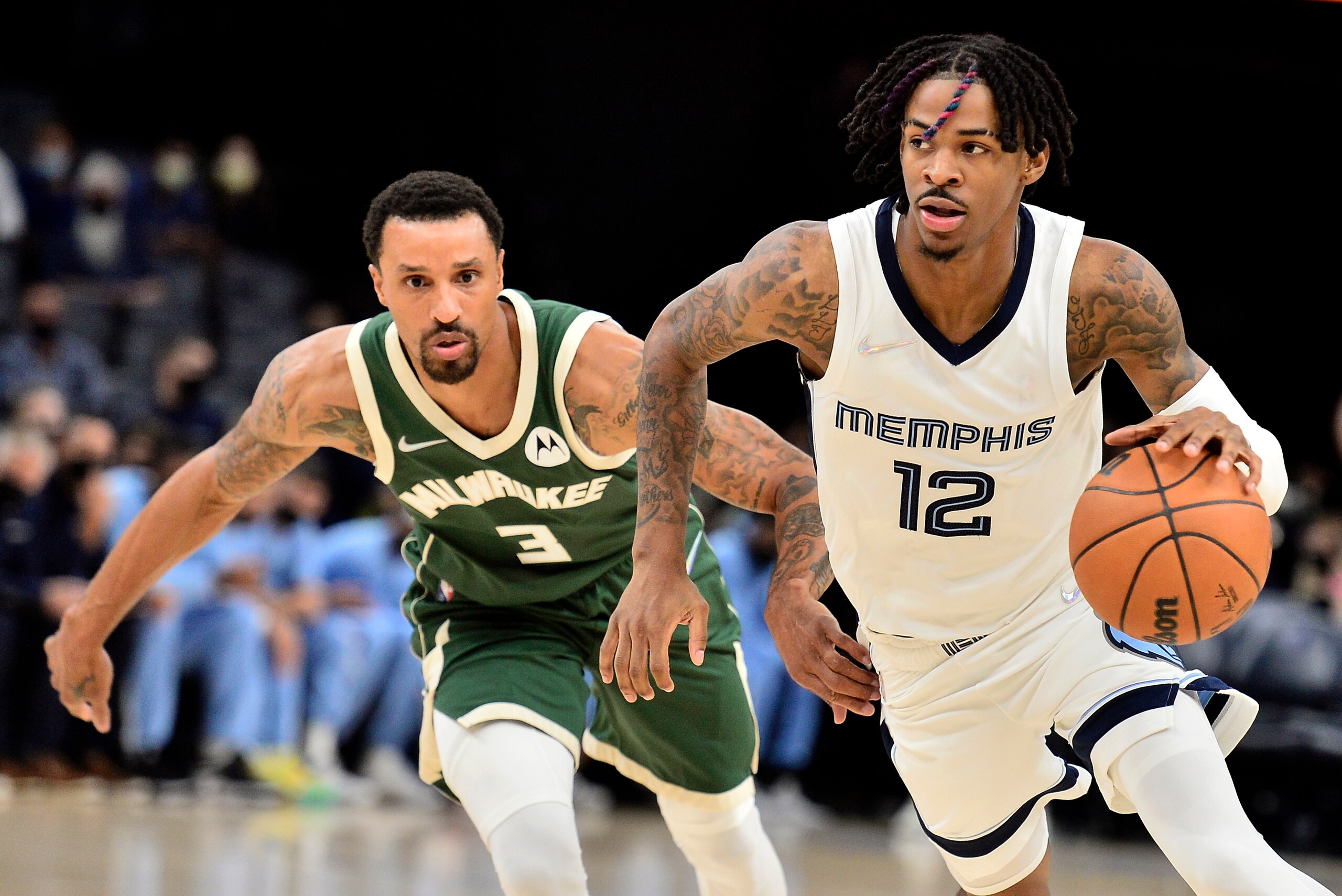 Memphis Grizzlies guard Ja Morant (12) handles the ball ahead of Milwaukee Bucks guard George Hill (3) in the first half of an NBA preseason basketball game Tuesday, Oct. 5, 2021, in Memphis, Tenn. (AP Photo/Brandon Dill)