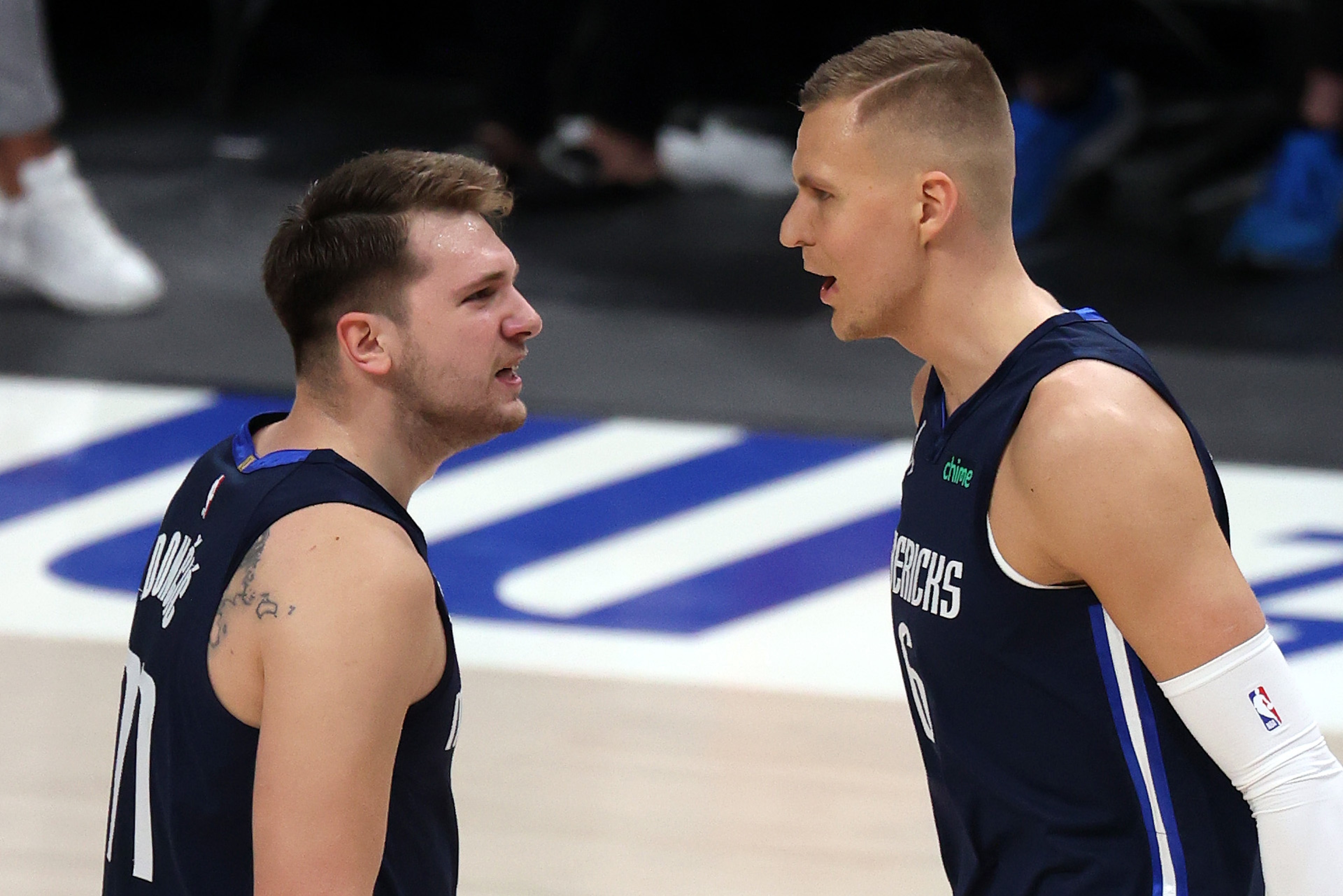 DALLAS, TEXAS - MAY 28: Luka Doncic #77 and Kristaps Porzingis #6 of the Dallas Mavericks react against the LA Clippers in the first quarter in game three of the Western Conference first round series at American Airlines Center on May 28, 2021 in Dallas, Texas. NOTE TO USER: User expressly acknowledges and agrees that, by downloading and or using this photograph, User is consenting to the terms and conditions of the Getty Images License Agreement. (Photo by Ronald Martinez/Getty Images) DALLAS, TEXAS - MAY 28: Luka Doncic #77 and Kristaps Porzingis #6 of the Dallas Mavericks react against the LA Clippers in the first quarter in game three of the Western Conference first round series at American Airlines Center on May 28, 2021 in Dallas, Texas. NOTE TO USER: User expressly acknowledges and agrees that, by downloading and or using this photograph, User is consenting to the terms and conditions of the Getty Images License Agreement. (Photo by Ronald Martinez/Getty Images)
