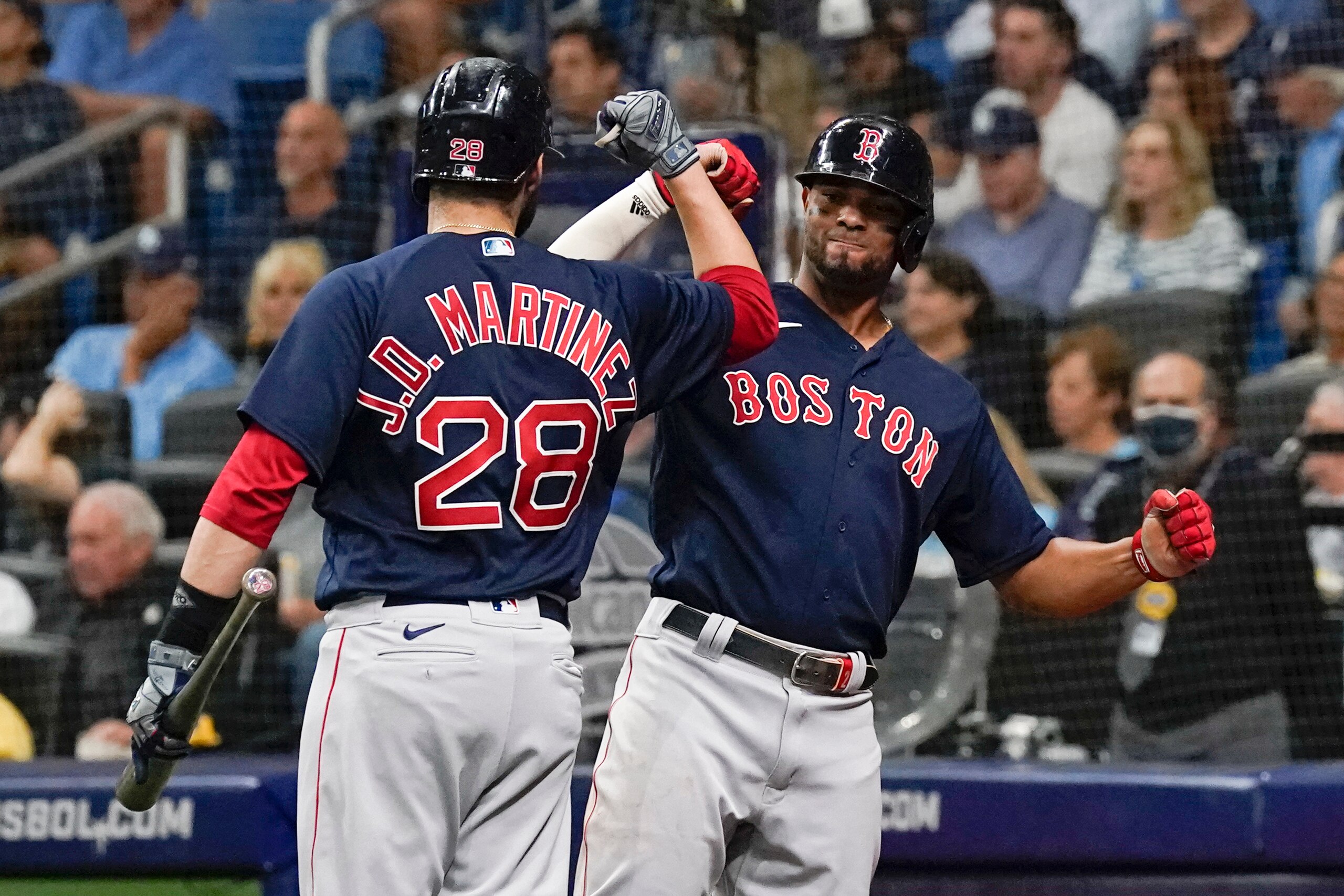 Boston Red Sox's Xander Bogaerts, right, celebrates his home run against the Tampa Bay Rays with J.D. Martinez (28) during the third inning of Game 2 of a baseball American League Division Series, Friday, Oct. 8, 2021, in St. Petersburg, Fla. (AP Photo/Steve Helber)
