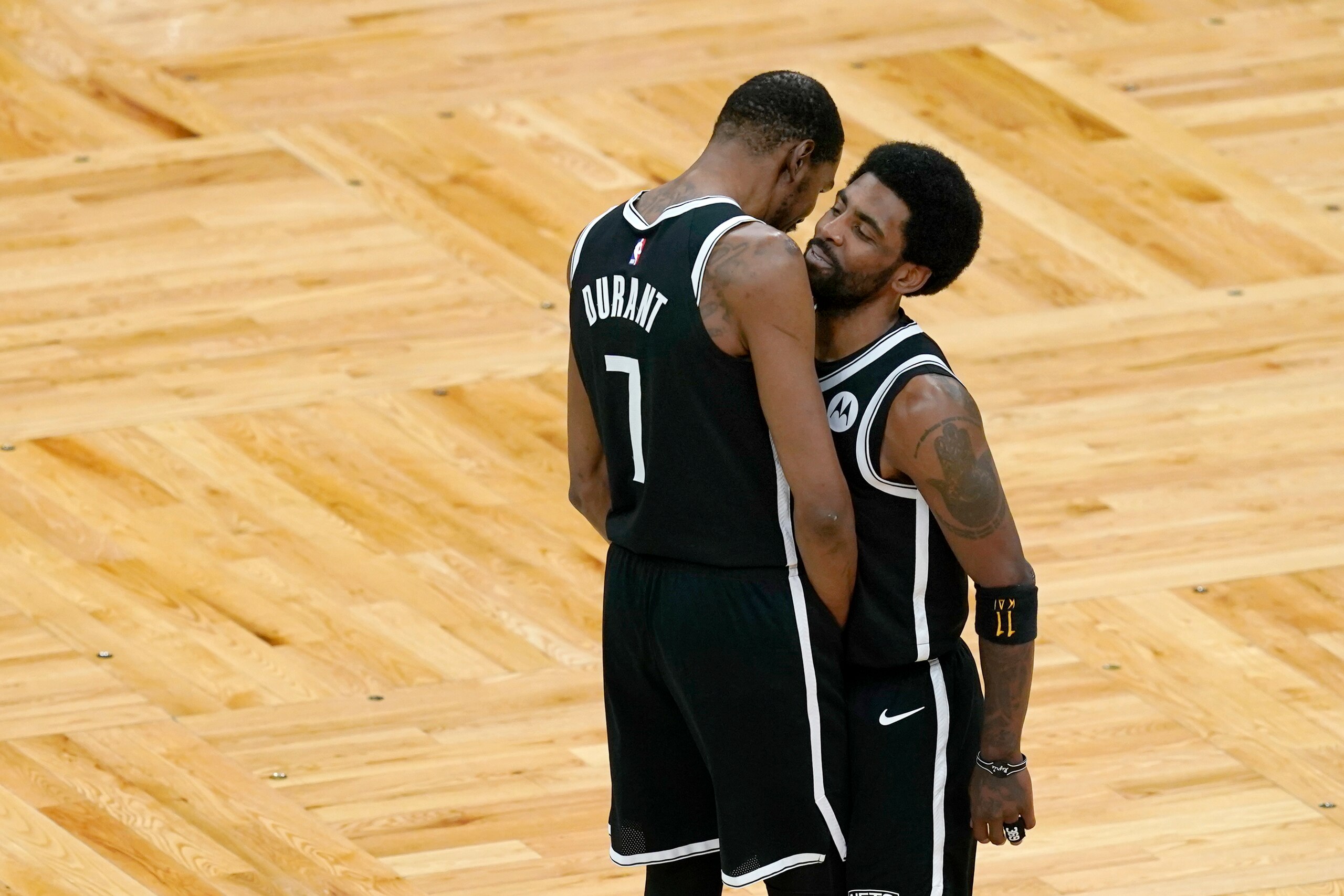 Brooklyn Nets forward Kevin Durant (7) has a word with Nets guard Kyrie Irving just before the tip-off in Game 4 against the Boston Celtics during an NBA basketball first-round playoff series, Sunday, May 30, 2021, in Boston. (AP Photo/Elise Amendola)
