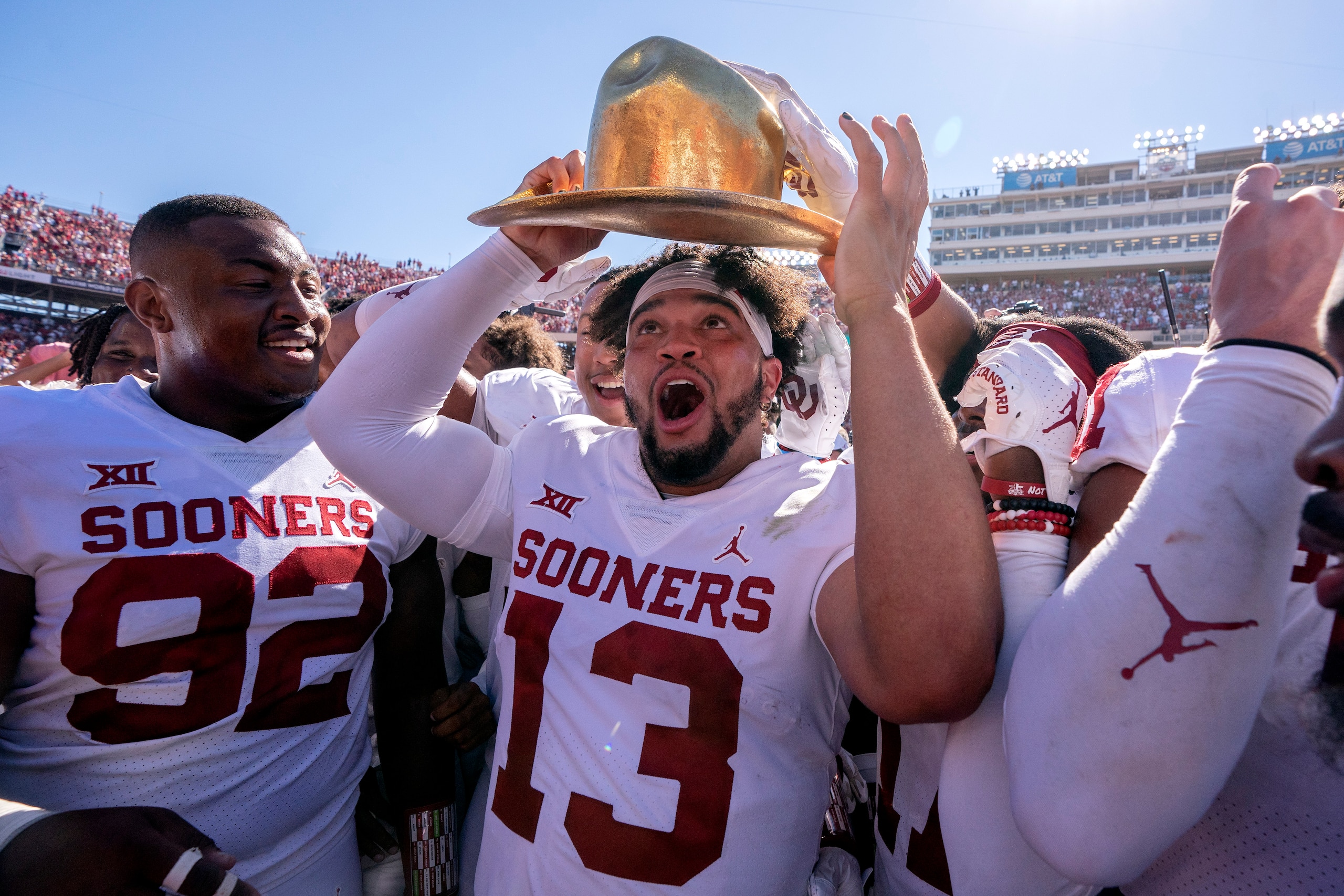 Oklahoma quarterback Caleb Williams (13) puts on the Golden Hat after coming off the bench to lead Oklahoma to a 54-48 win over Texas in an NCAA college football game at the Cotton Bowl, Saturday, Oct. 9, 2021, in Dallas. (AP Photo/Jeffrey McWhorter)