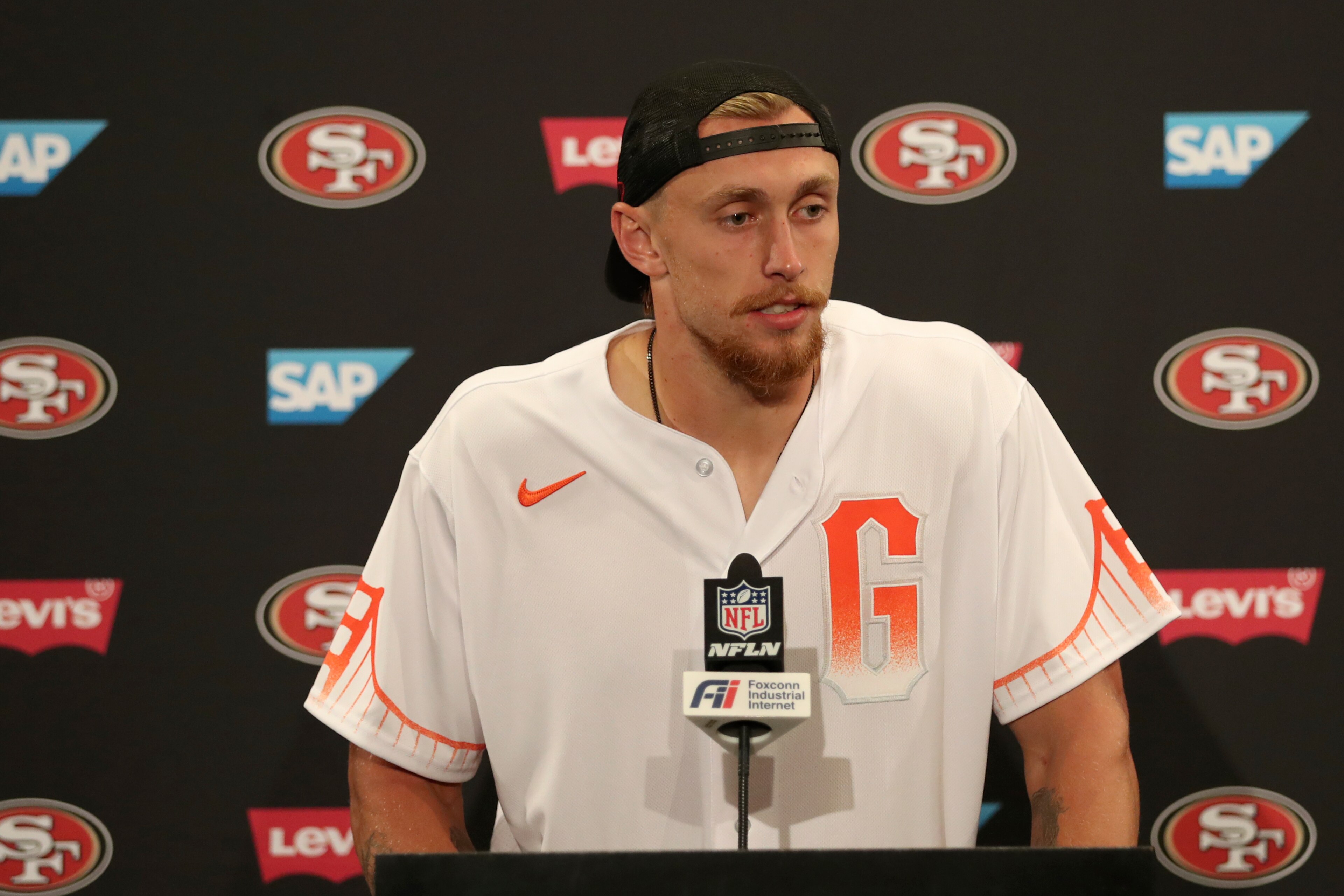 San Francisco 49ers tight end George Kittle wears a San Francisco Giants baseball jersey as he speaks at a news conference after an NFL football game against the Seattle Seahawks in Santa Clara, Calif., Sunday, Oct. 3, 2021. (AP Photo/Jed Jacobsohn)