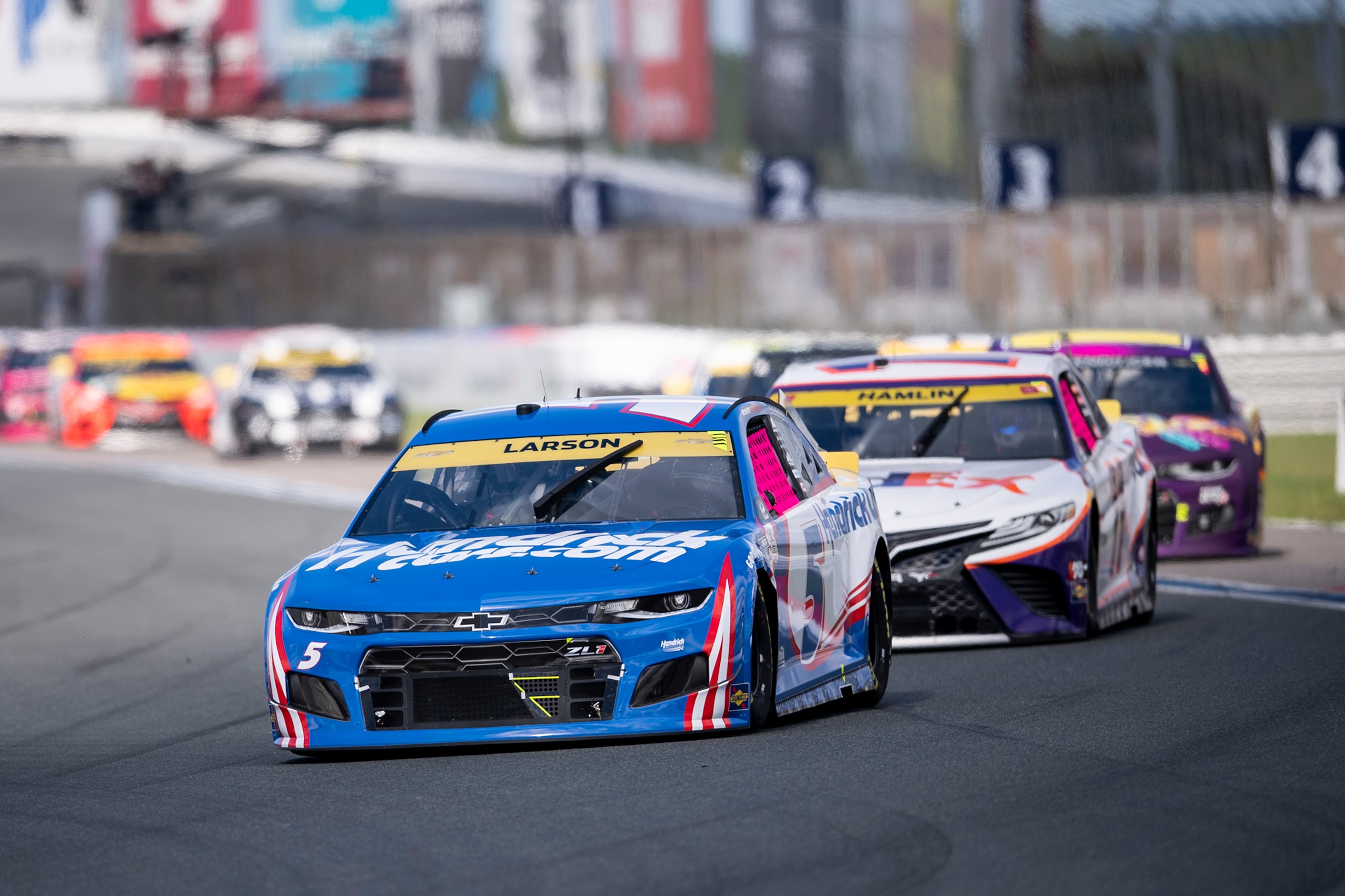 Kyle Larson (5) leads a pack of cars during a NASCAR Cup Series auto racing race at Charlotte Motor Speedway, Sunday, Oct. 10, 2021, in Concord, N.C. (AP Photo/Matt Kelley)