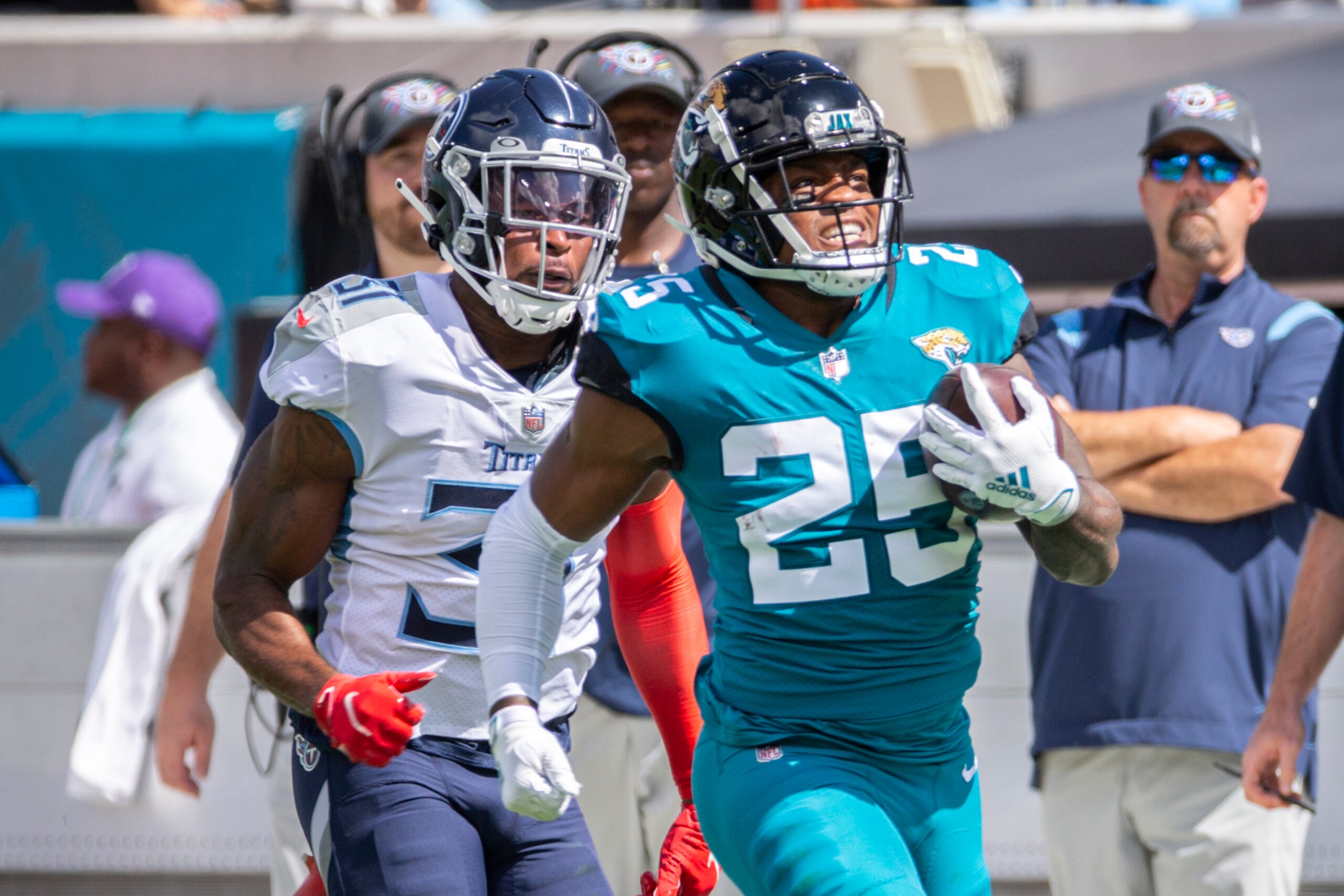 Jacksonville Jaguars running back James Robinson (25) runs down the sideline while being pursued by Tennessee Titans safety Kevin Byard (31) during the first half of an NFL football game, Sunday, Oct. 10, 2021, in Jacksonville, Fla. (AP Photo/Stephen B. Morton)