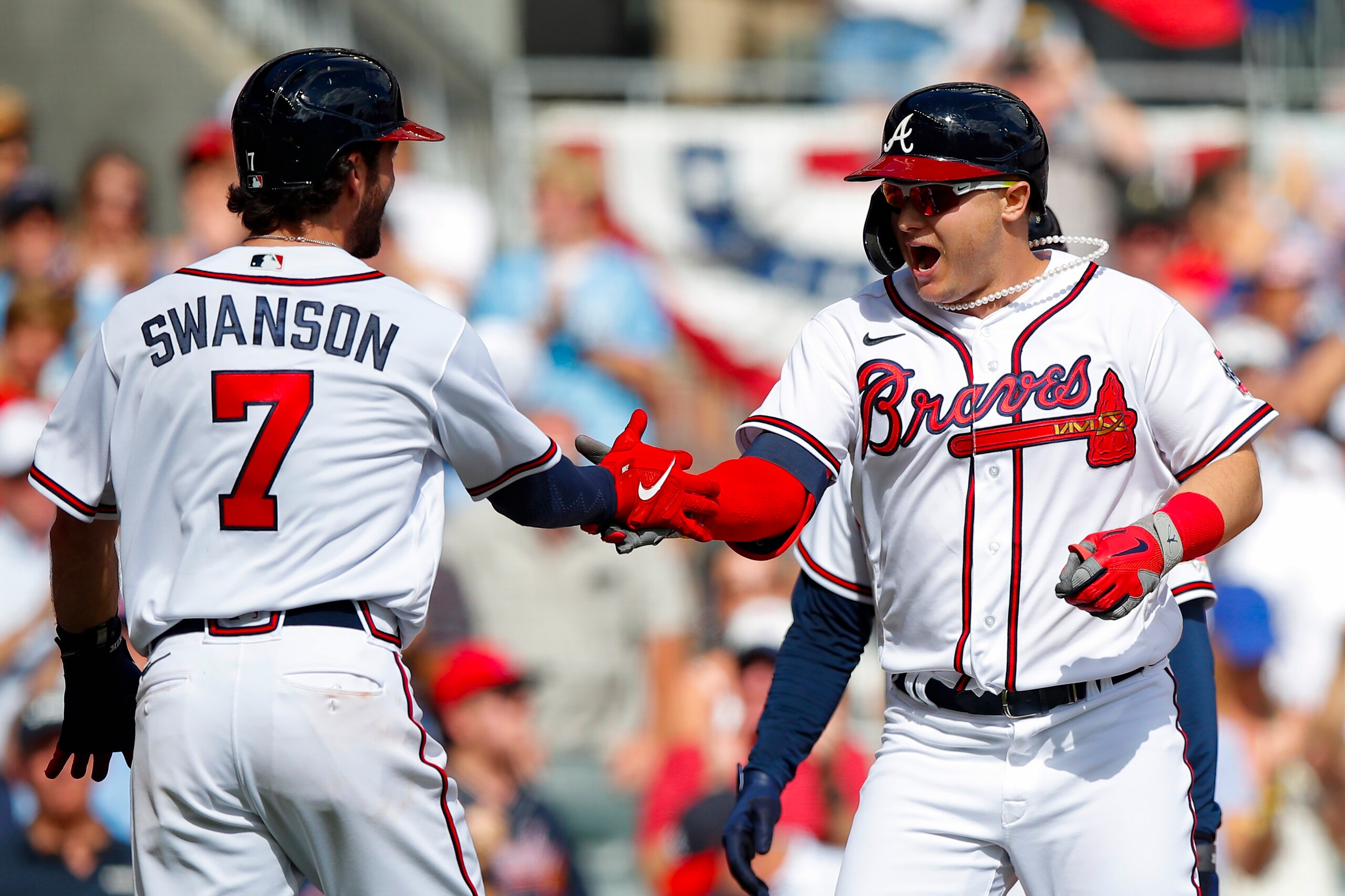 ATLANTA, GEORGIA - OCTOBER 11: Joc Pederson #22 of the Atlanta Braves high fives Dansby Swanson #7 after hitting a three run home during the fifth inning against the Milwaukee Brewers in game 3 of the National League Division Series at Truist Park on October 11, 2021 in Atlanta, Georgia. (Photo by Todd Kirkland/Getty Images)
