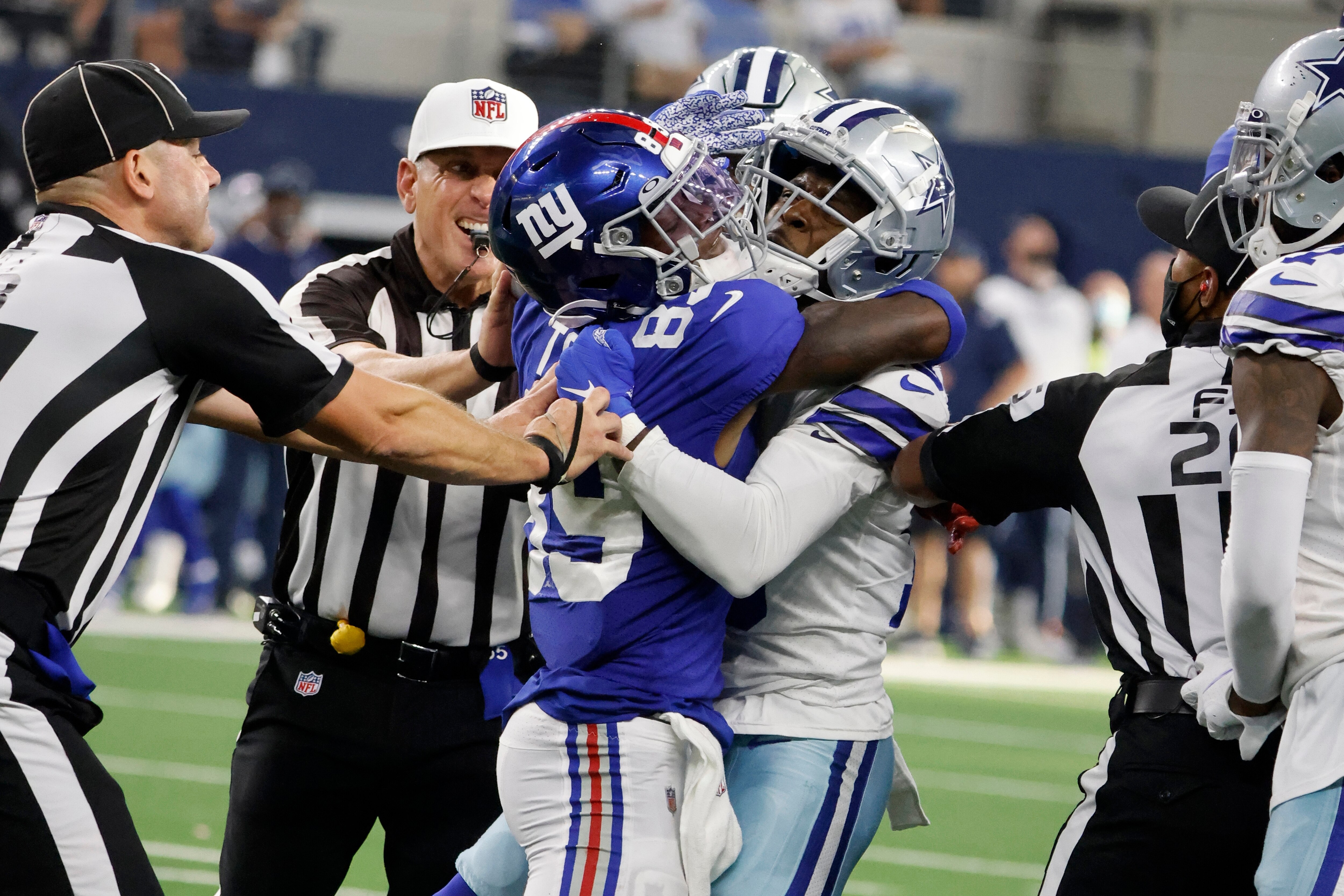 Officials attempt to separate New York Giants' Kadarius Toney (89) and Dallas Cowboys' Damontae Kazee, right, after Toney threw a punch at Kazee in the second half of an NFL football game in Arlington, Texas, Sunday, Oct. 10, 2021. (AP Photo/Michael Ainsworth)