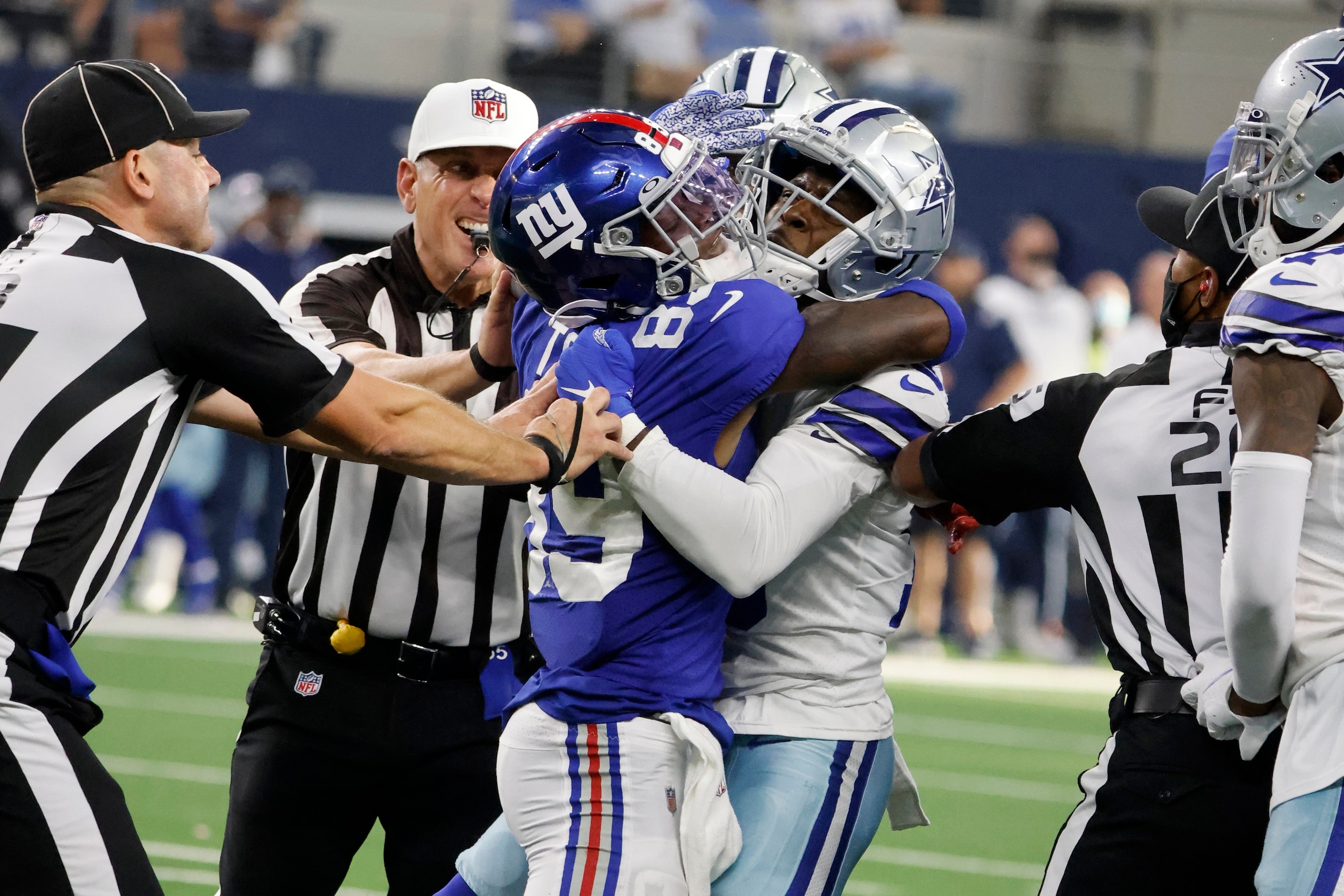 Officials attempt to separate New York Giants' Kadarius Toney (89) and Dallas Cowboys' Damontae Kazee, right, after Toney threw a punch at Kazee in the second half of an NFL football game in Arlington, Texas, Sunday, Oct. 10, 2021. (AP Photo/Michael Ainsworth)