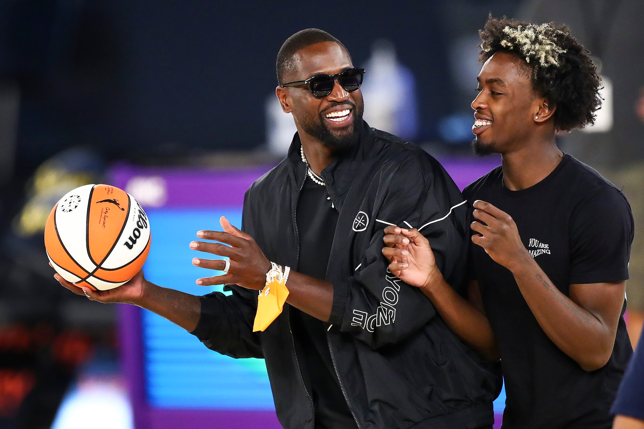 LOS ANGELES, CALIFORNIA - JUNE 30: Former NBA player Dwyane Wade and his son Zaire Wade spend time on the court after the game between the Los Angeles Sparks and the Las Vegas Aces at Los Angeles Convention Center on June 30, 2021 in Los Angeles, California. NOTE TO USER: User expressly acknowledges and agrees that, by downloading and or using this photograph, User is consenting to the terms and conditions of the Getty Images License Agreement. (Photo by Meg Oliphant/Getty Images)