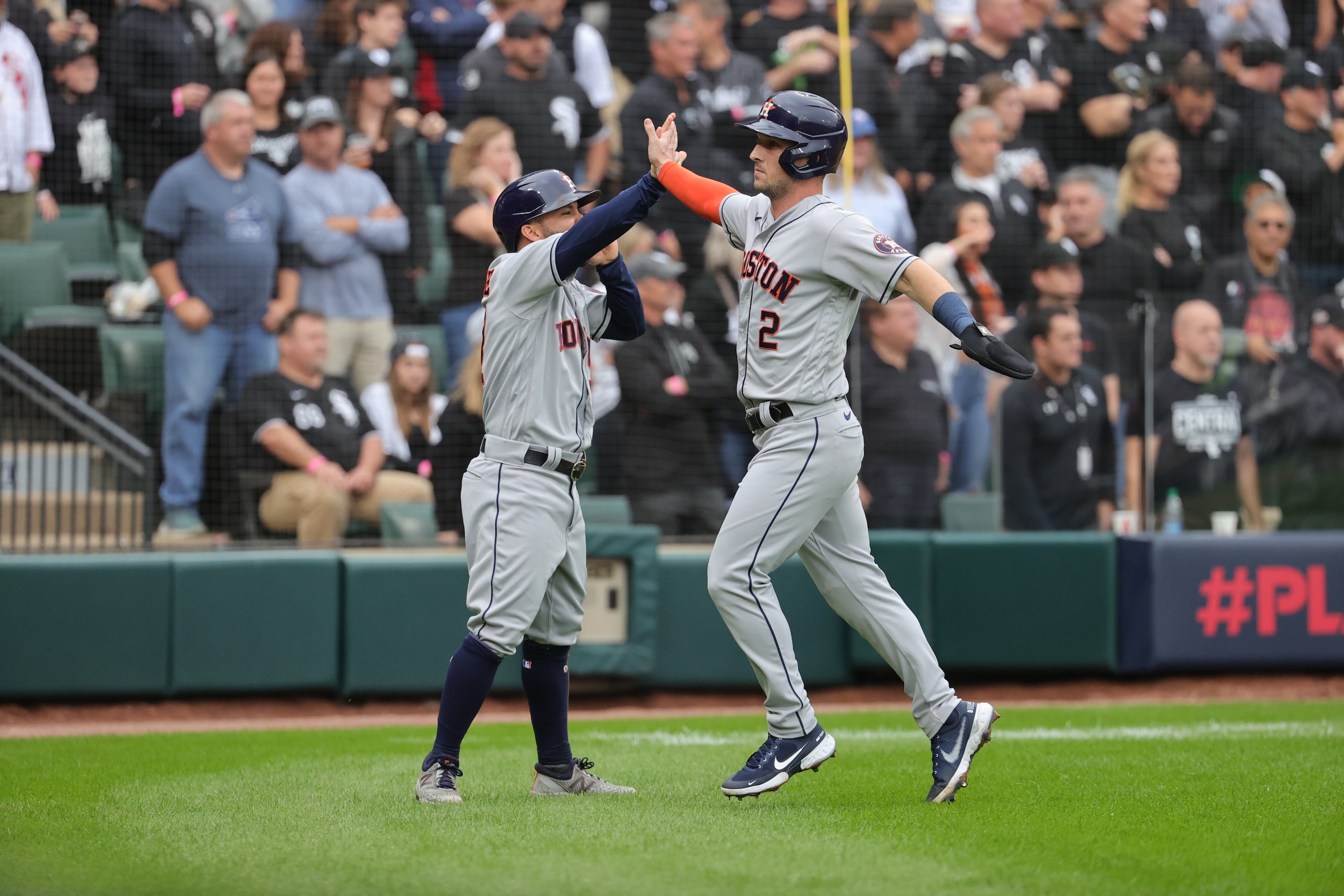 CHICAGO, ILLINOIS - OCTOBER 12:  Jose Altuve #27 and Alex Bregman #2 of the Houston Astros celebrate after scoring on a two-run double by Carlos Correa #1during the 3rd inning of Game 4 of the American League Division Series against the Chicago White Sox at Guaranteed Rate Field on October 12, 2021 in Chicago, Illinois. (Photo by Jonathan Daniel/Getty Images)