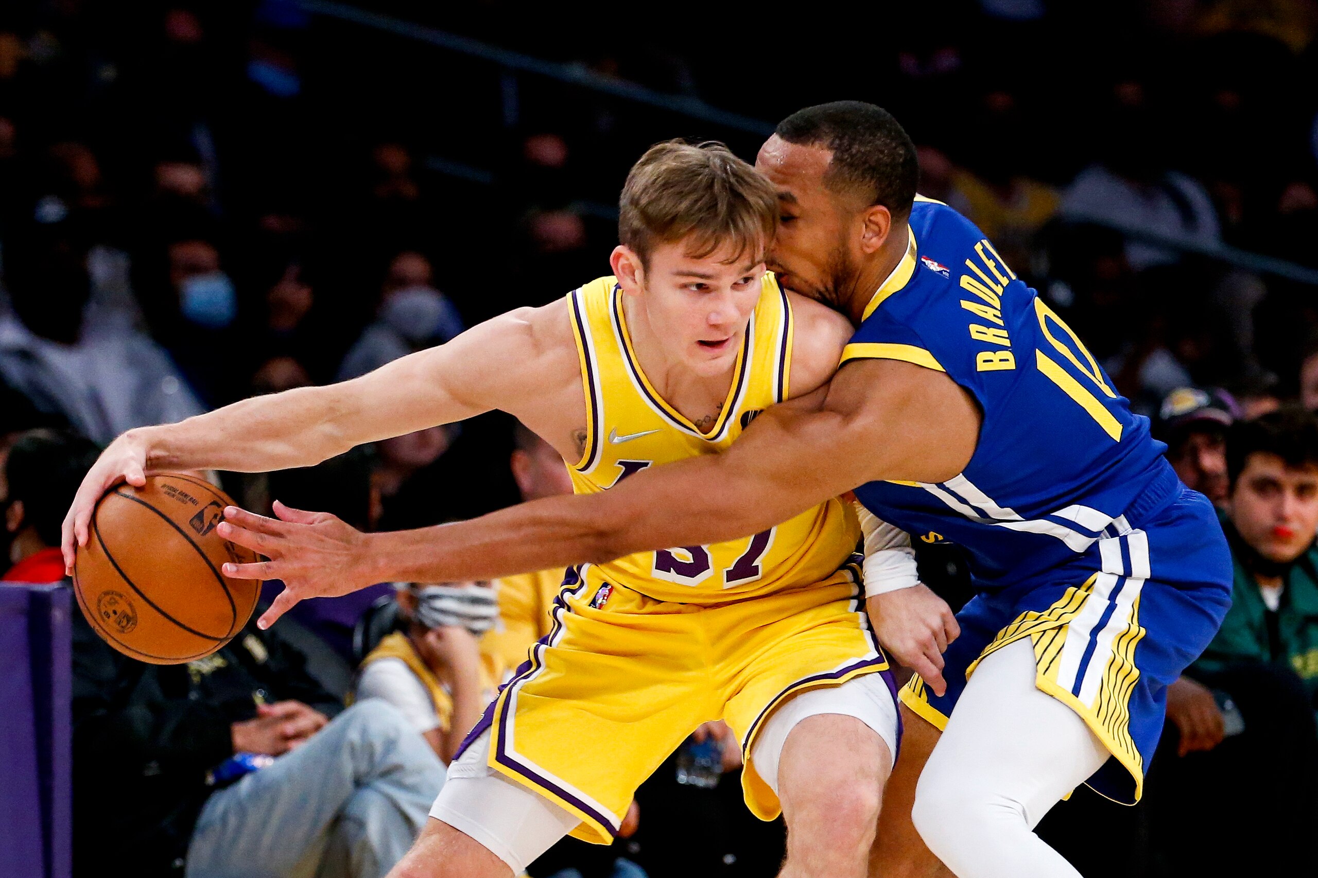 Los Angeles Lakers guard Mac McClung, left, is defended by Golden State Warriors guard Avery Bradley during the second half of a preseason NBA basketball game in Los Angeles, Tuesday, Oct. 12, 2021. (AP Photo/Ringo H.W. Chiu)