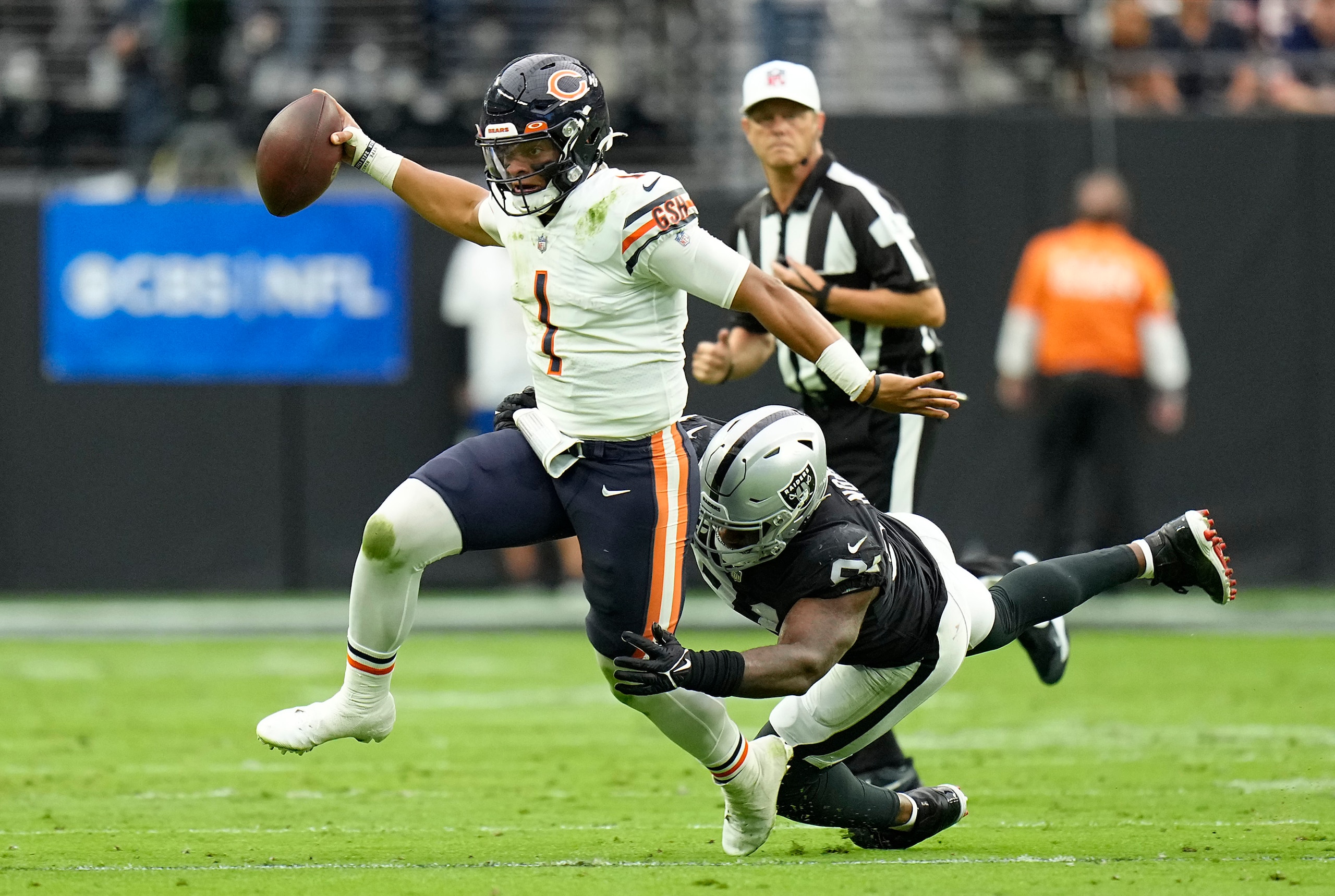 LAS VEGAS, NEVADA - OCTOBER 10: Justin Fields #1 of the Chicago Bears runs with the ball as Yannick Ngakoue #91 of the Las Vegas Raiders defends during the first half at Allegiant Stadium on October 10, 2021 in Las Vegas, Nevada. (Photo by Jeff Bottari/Getty Images)