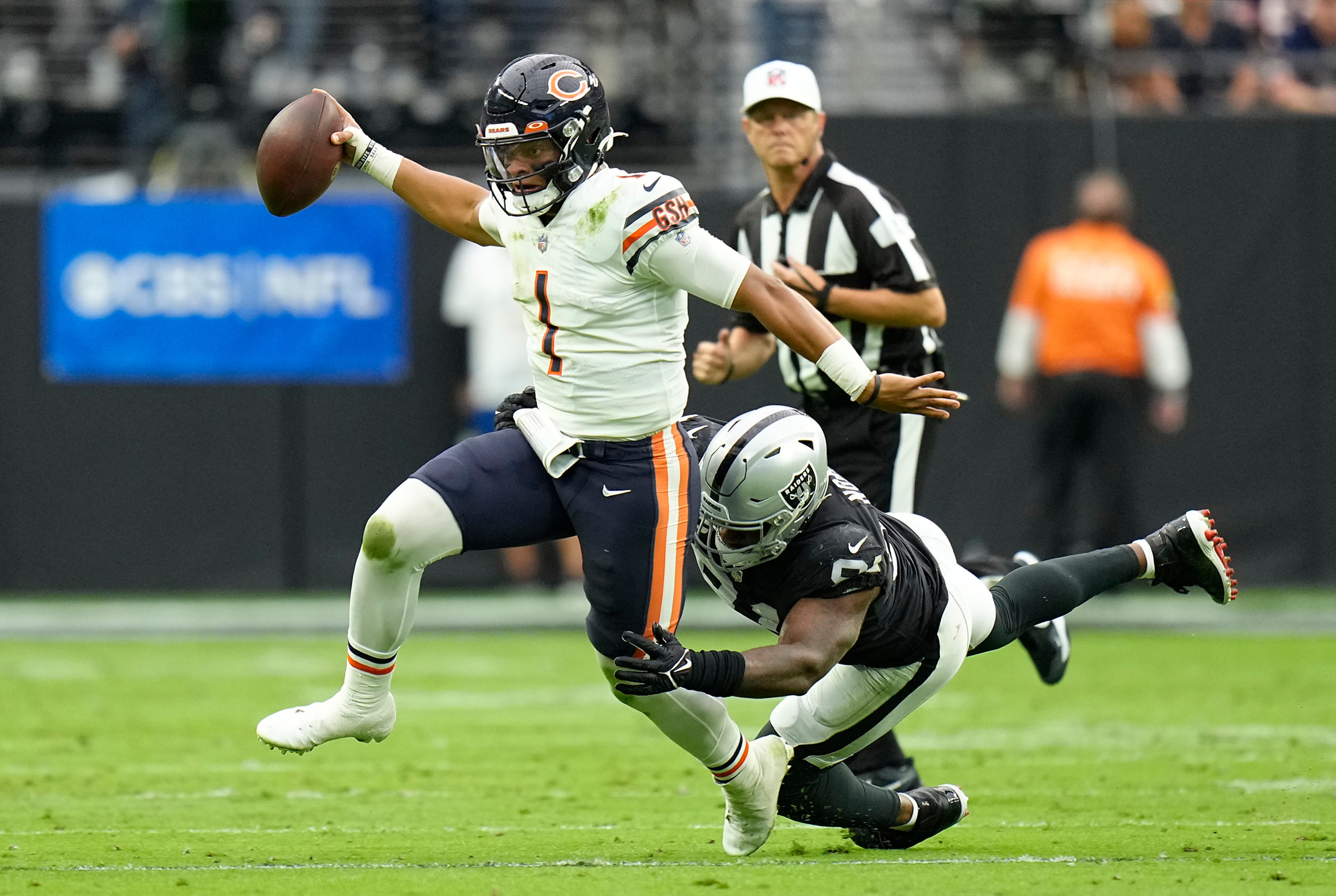 LAS VEGAS, NEVADA - OCTOBER 10: Justin Fields #1 of the Chicago Bears runs with the ball as Yannick Ngakoue #91 of the Las Vegas Raiders defends during the first half at Allegiant Stadium on October 10, 2021 in Las Vegas, Nevada. (Photo by Jeff Bottari/Getty Images)
