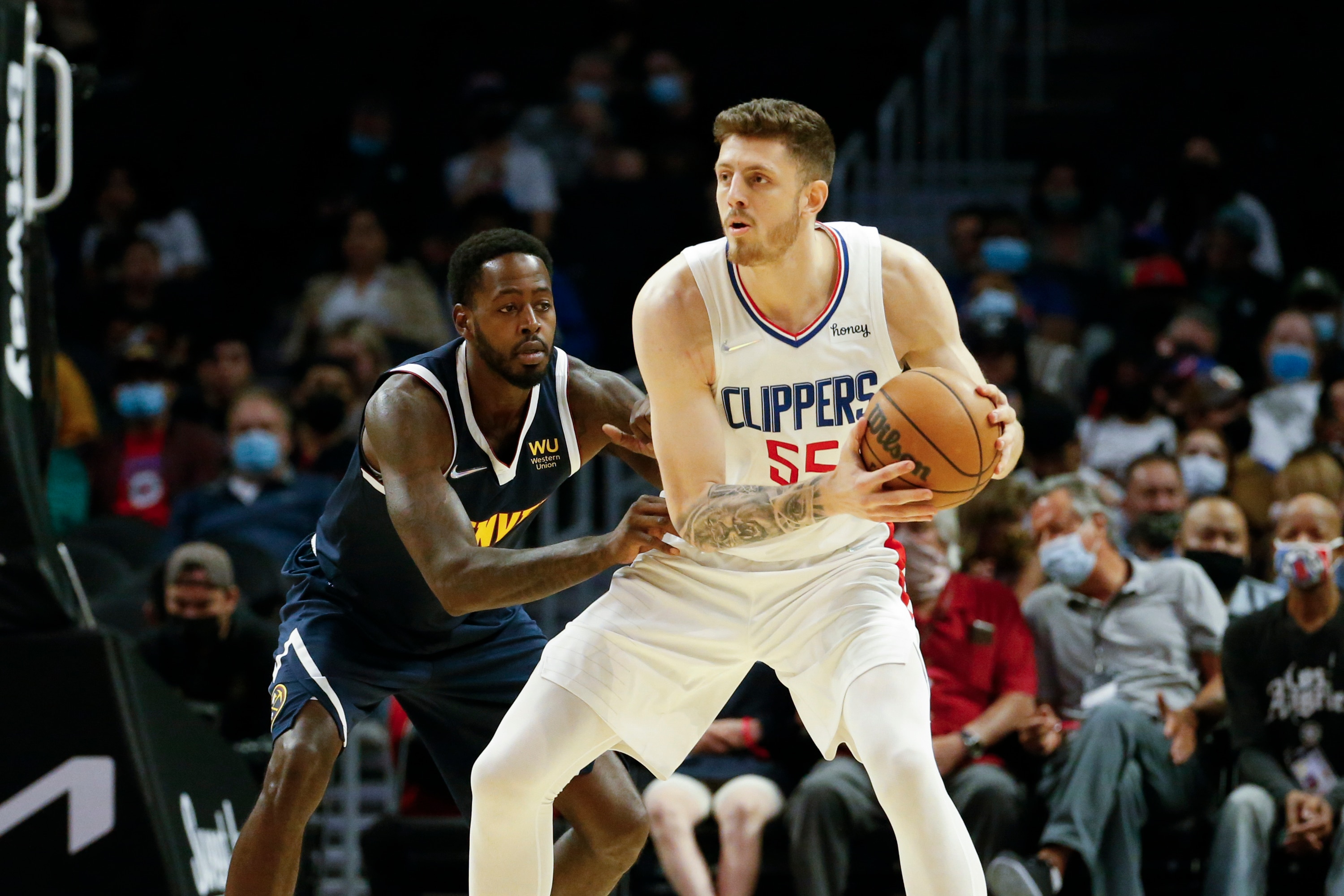 Los Angeles Clippers Center Isaiah Hartenstein (55) is defended by Denver Nuggets forward JaMychal Green (0) during the first half of a preseason NBA basketball game, Monday, Oct. 4, 2021, in Los Angeles. (AP Photo/Ringo H.W. Chiu)