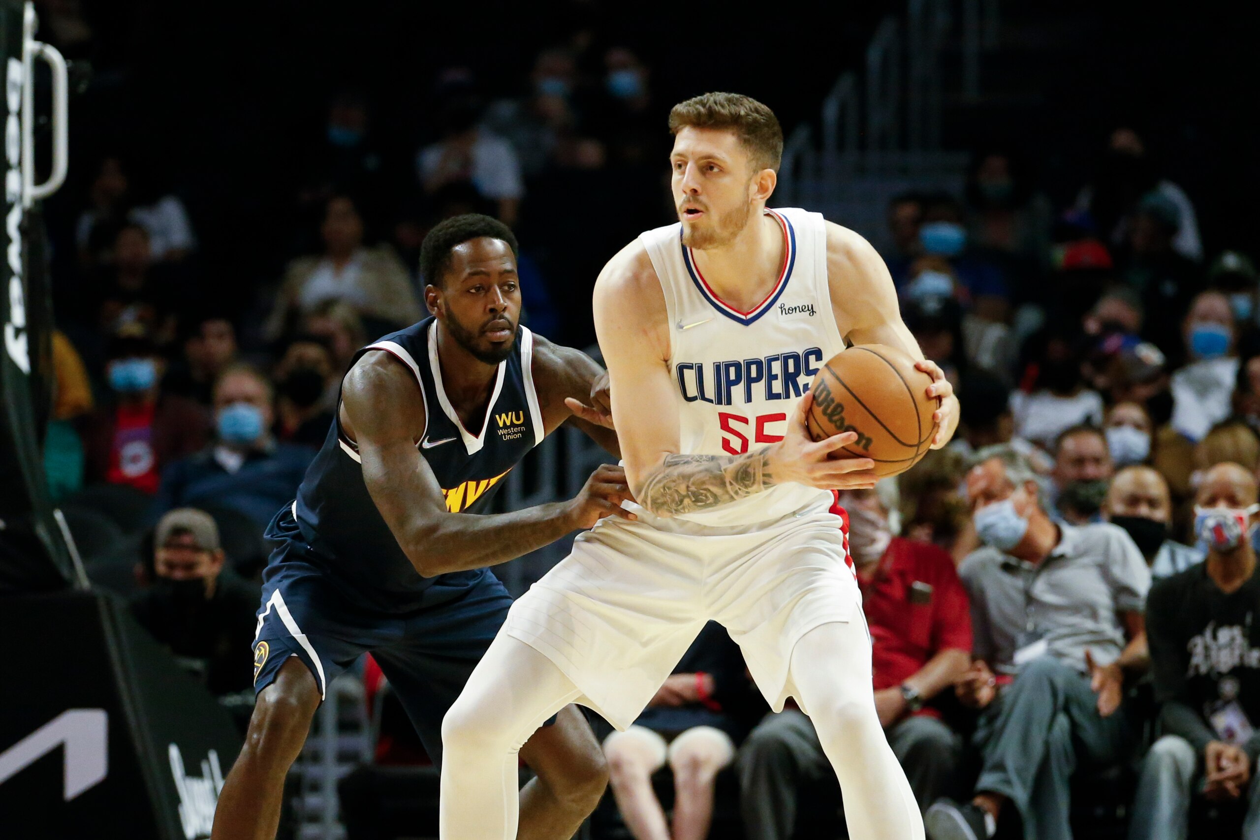 Los Angeles Clippers Center Isaiah Hartenstein (55) is defended by Denver Nuggets forward JaMychal Green (0) during the first half of a preseason NBA basketball game, Monday, Oct. 4, 2021, in Los Angeles. (AP Photo/Ringo H.W. Chiu)