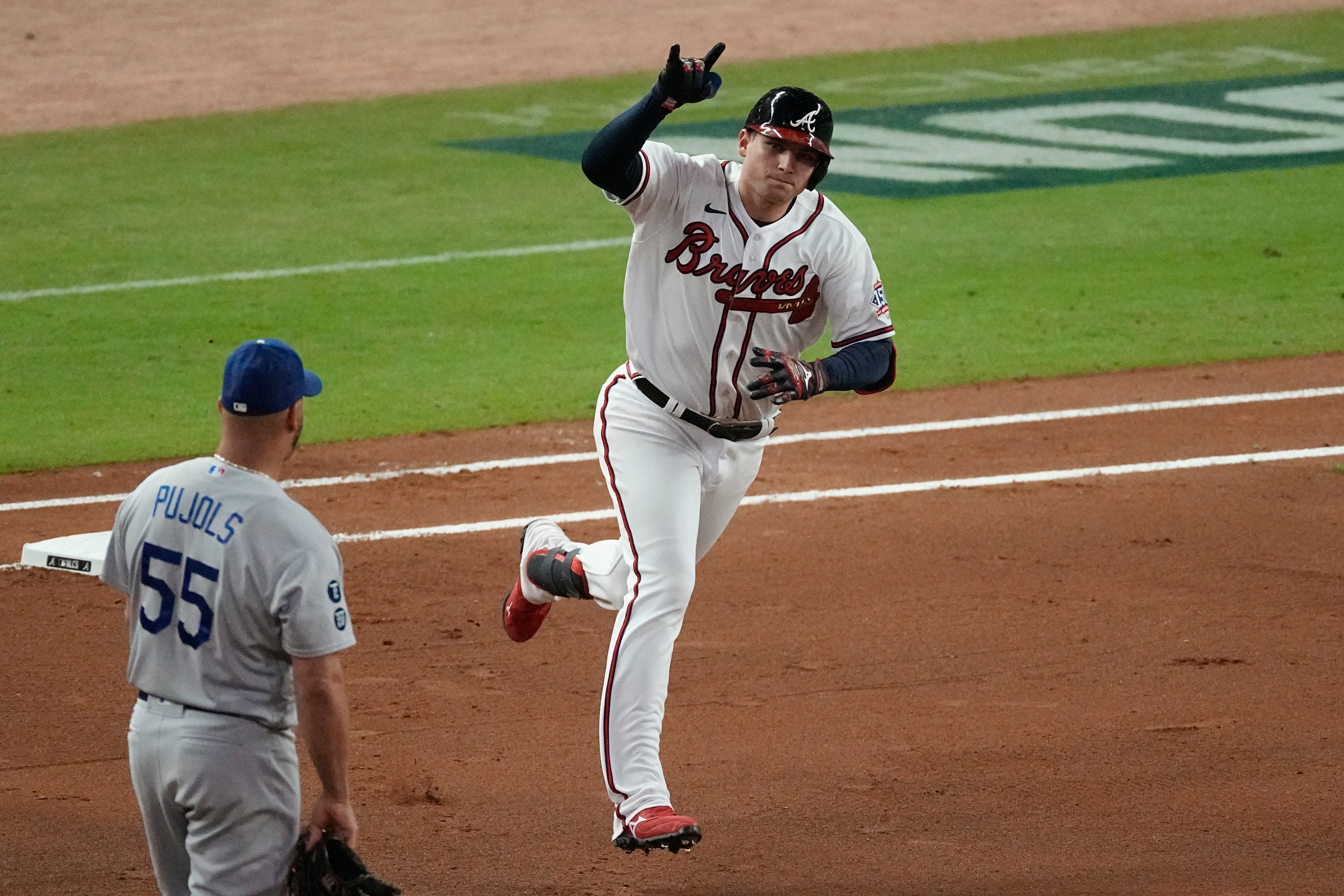 Atlanta Braves' Austin Riley runs past Los Angeles Dodgers first baseman Albert Pujols (55) after hitting a home run during the fourth inning in Game 1 of baseball's National League Championship Series Saturday, Oct. 16, 2021, in Atlanta. (AP Photo/John Bazemore)