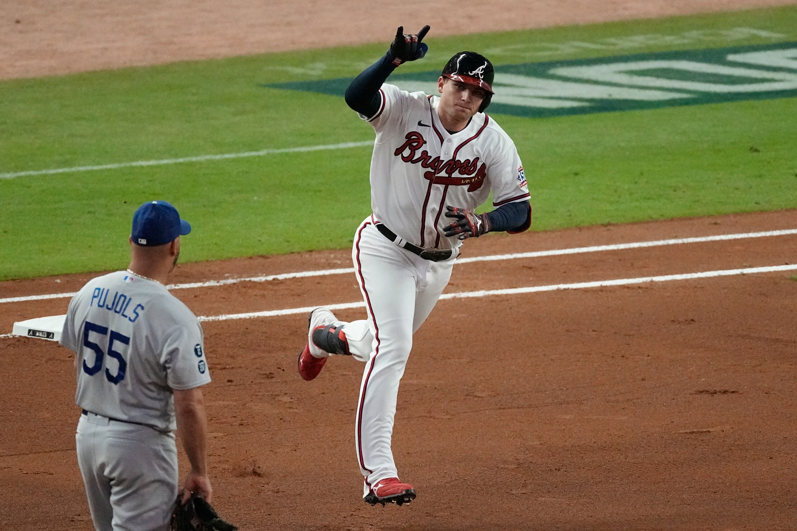 Atlanta Braves' Austin Riley runs past Los Angeles Dodgers first baseman Albert Pujols (55) after hitting a home run during the fourth inning in Game 1 of baseball's National League Championship Series Saturday, Oct. 16, 2021, in Atlanta. (AP Photo/John Bazemore)