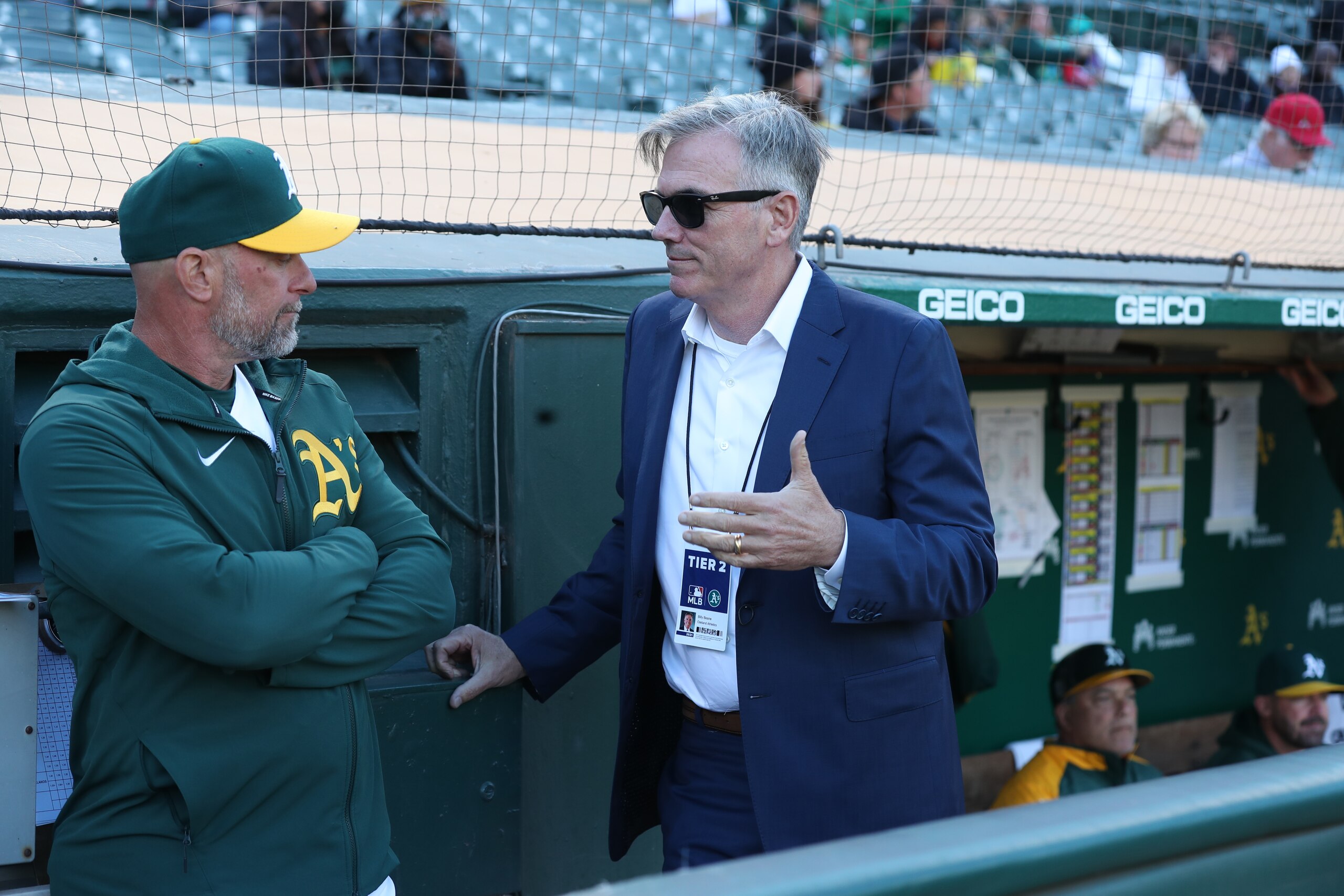 OAKLAND, CA - JUNE 08: Third Base Coach Mark Kotsay #7 and Executive Vice President of Baseball Operations Billy Beane of the Oakland Athletics talk in the dugout before the game against the Arizona Diamondbacks at RingCentral Coliseum on June 8, 2021 in Oakland, California. The Athletics defeated the Diamondbacks 5-2. (Photo by Michael Zagaris/Oakland Athletics/Getty Images)