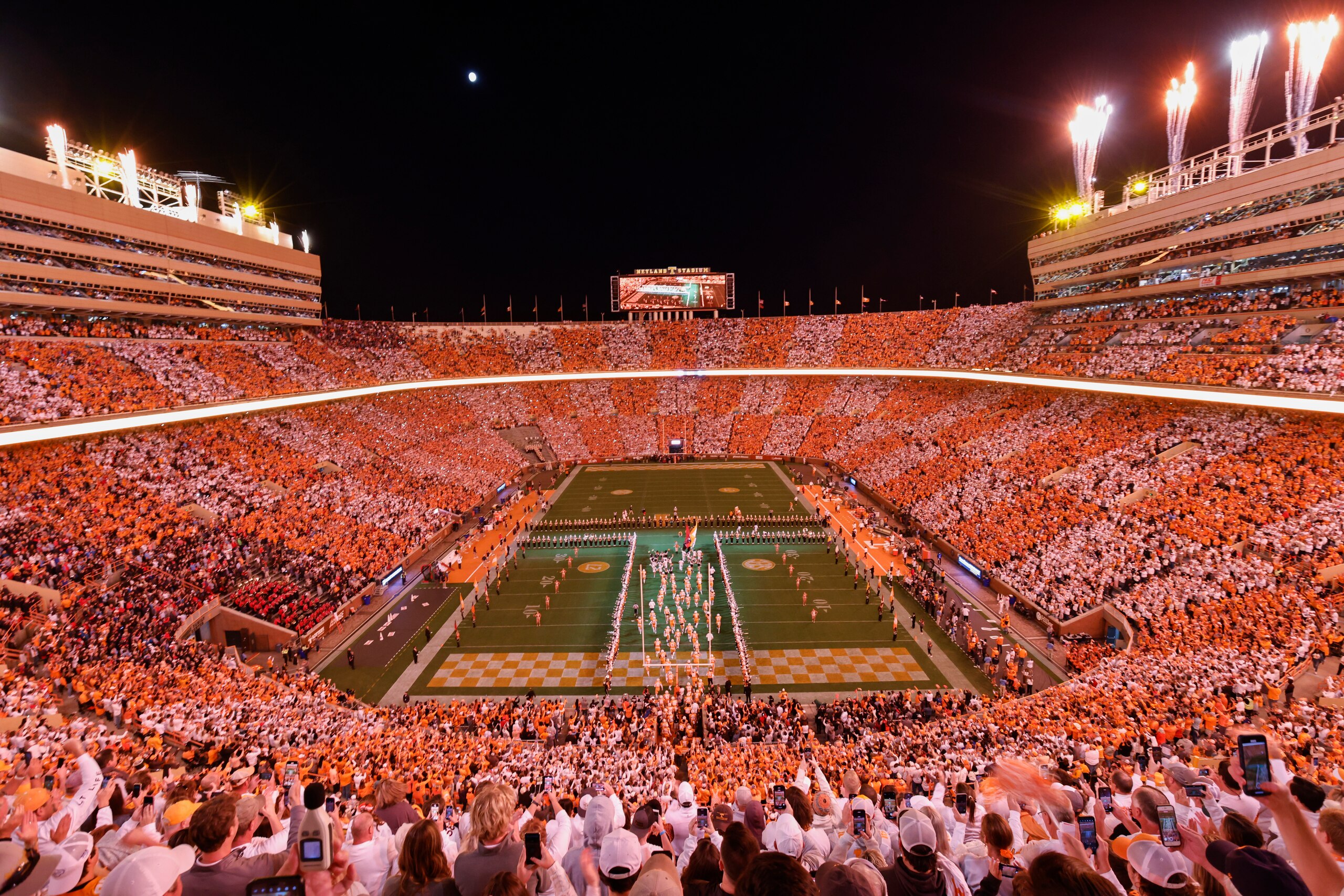 Fans dressed in orange and white form the checkerboard pattern in Neyland Stadium as Tennessee players run through the "T" before an NCAA college football game against Mississippi Saturday, Oct. 16, 2021, in Knoxville, Tenn. (AP Photo/Wade Payne)