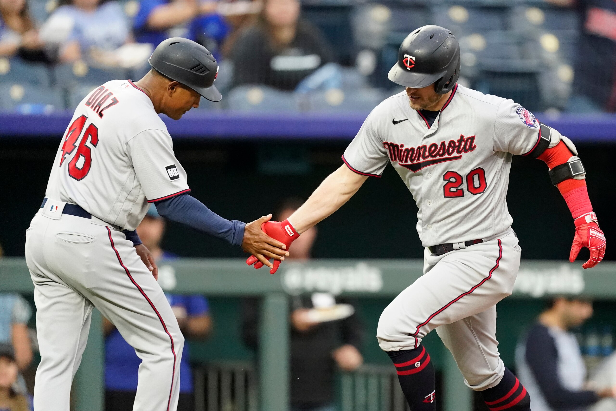 Minnesota Twins' Josh Donaldson (20) celebrates with third base coach Tony Diaz after hitting a solo home run during the first inning of a baseball game Saturday, Oct. 2, 2021, in Kansas City, Mo. (AP Photo/Charlie Riedel)